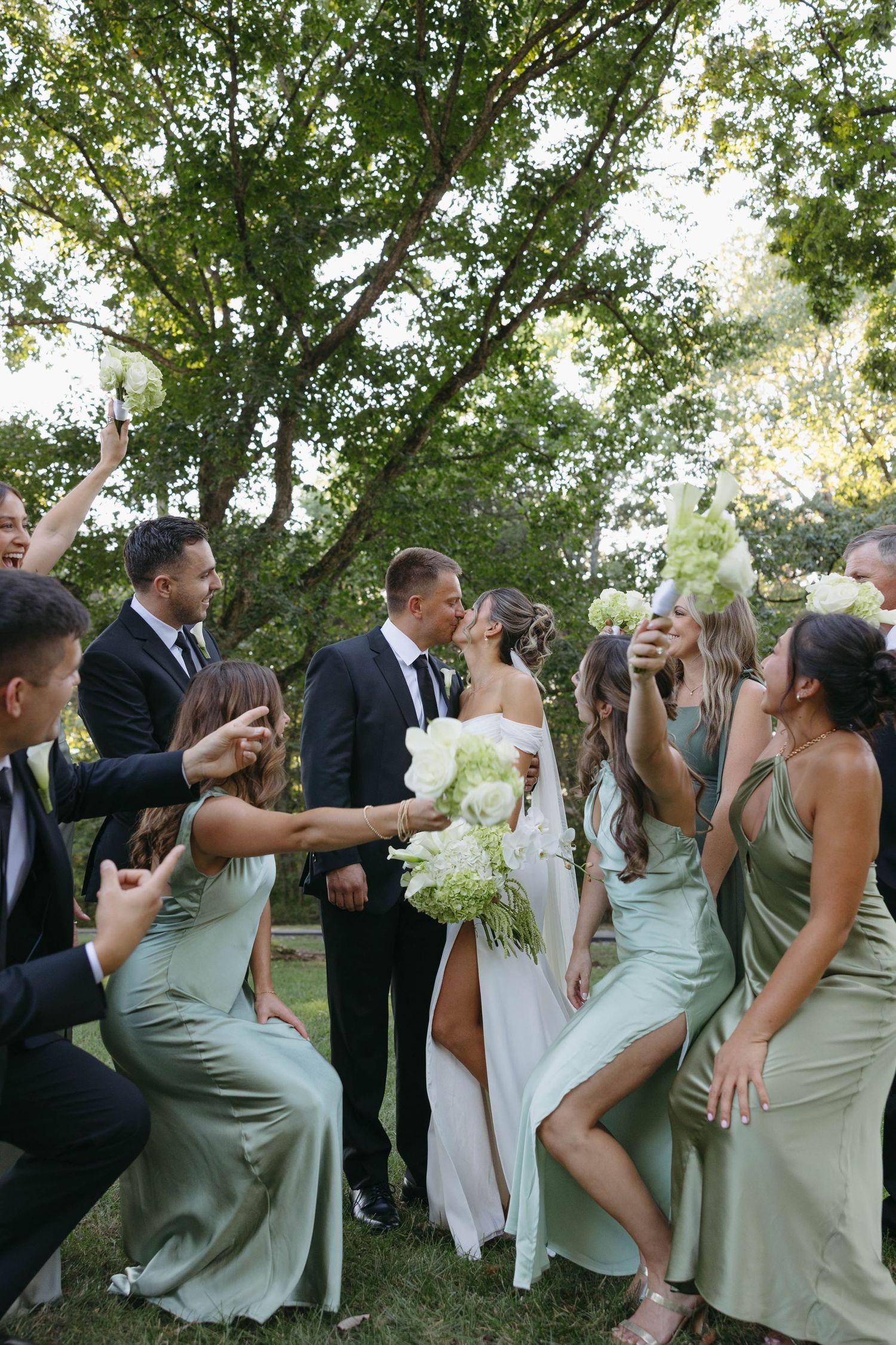 Birmingham Alabama Photographer capturing bride and groom kissing in a field, with bridal party, at Iris Woods Venue in Nashville, Tennessee