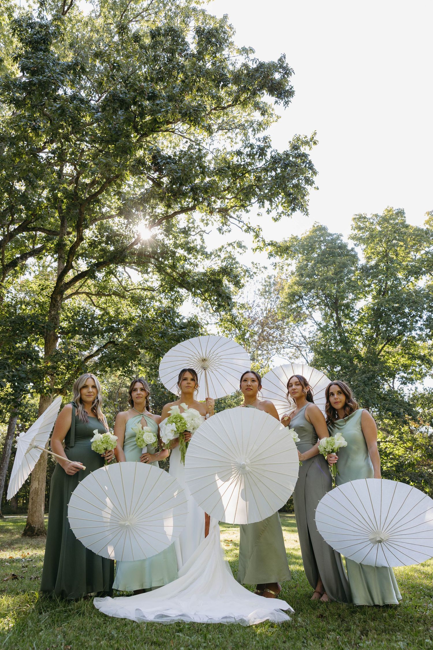 Birmingham Alabama Photographer capturing bride and bridesmaids posing with their parasols at Iris Woods Venue in Nashville, Tennessee