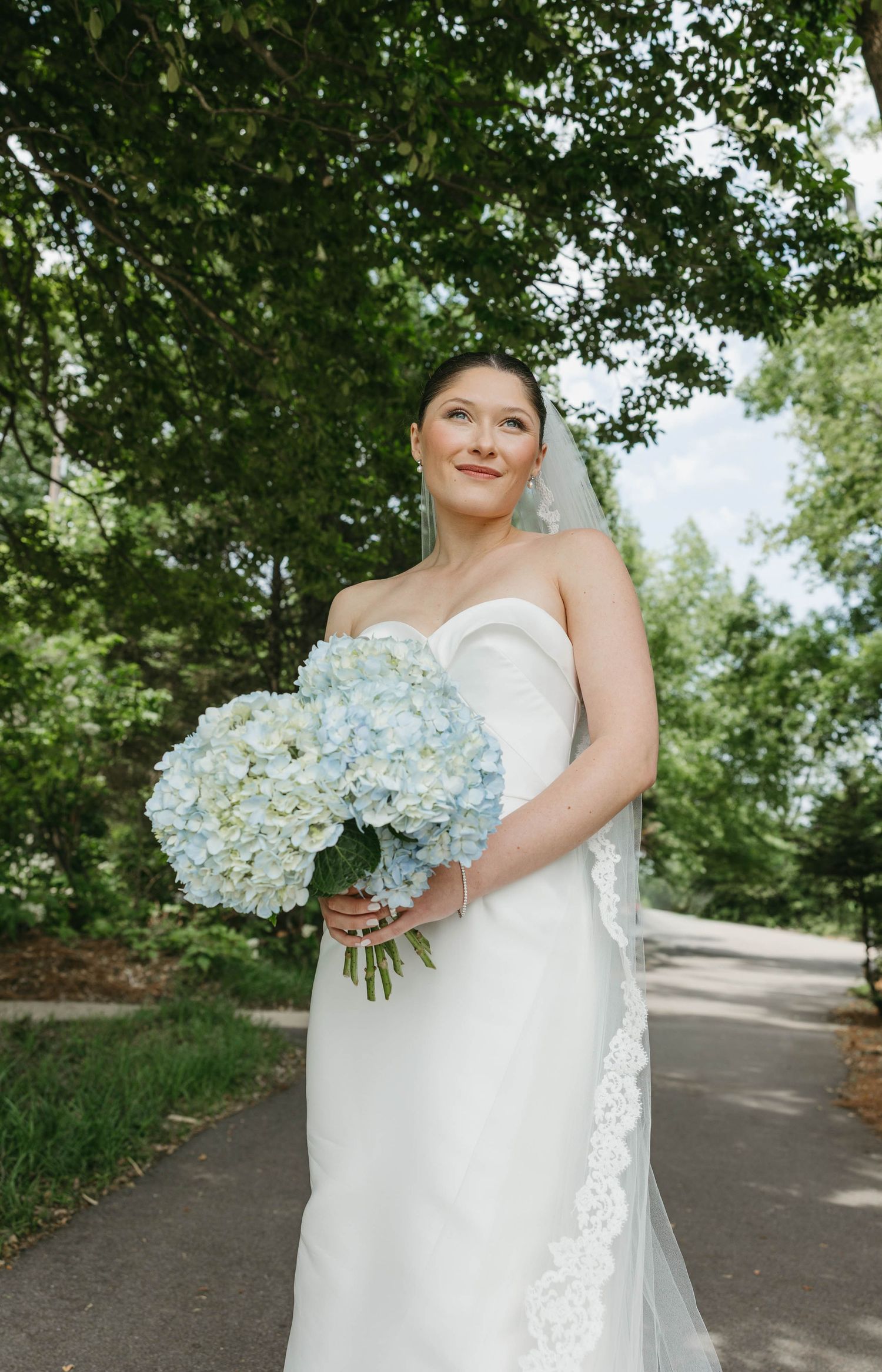 portrait of bride holding blue hydrangeas