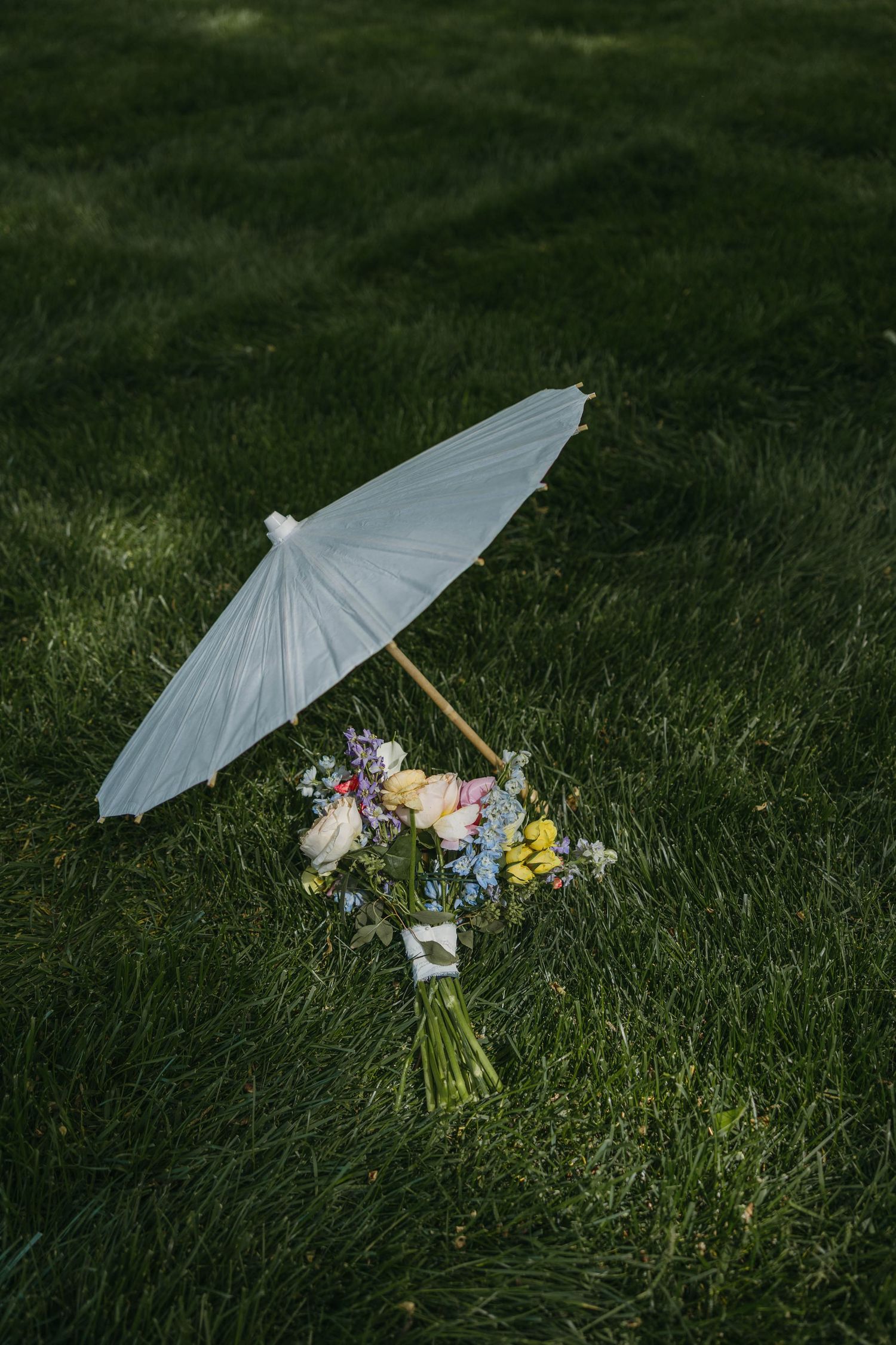 flowers and parasol laying in the grass