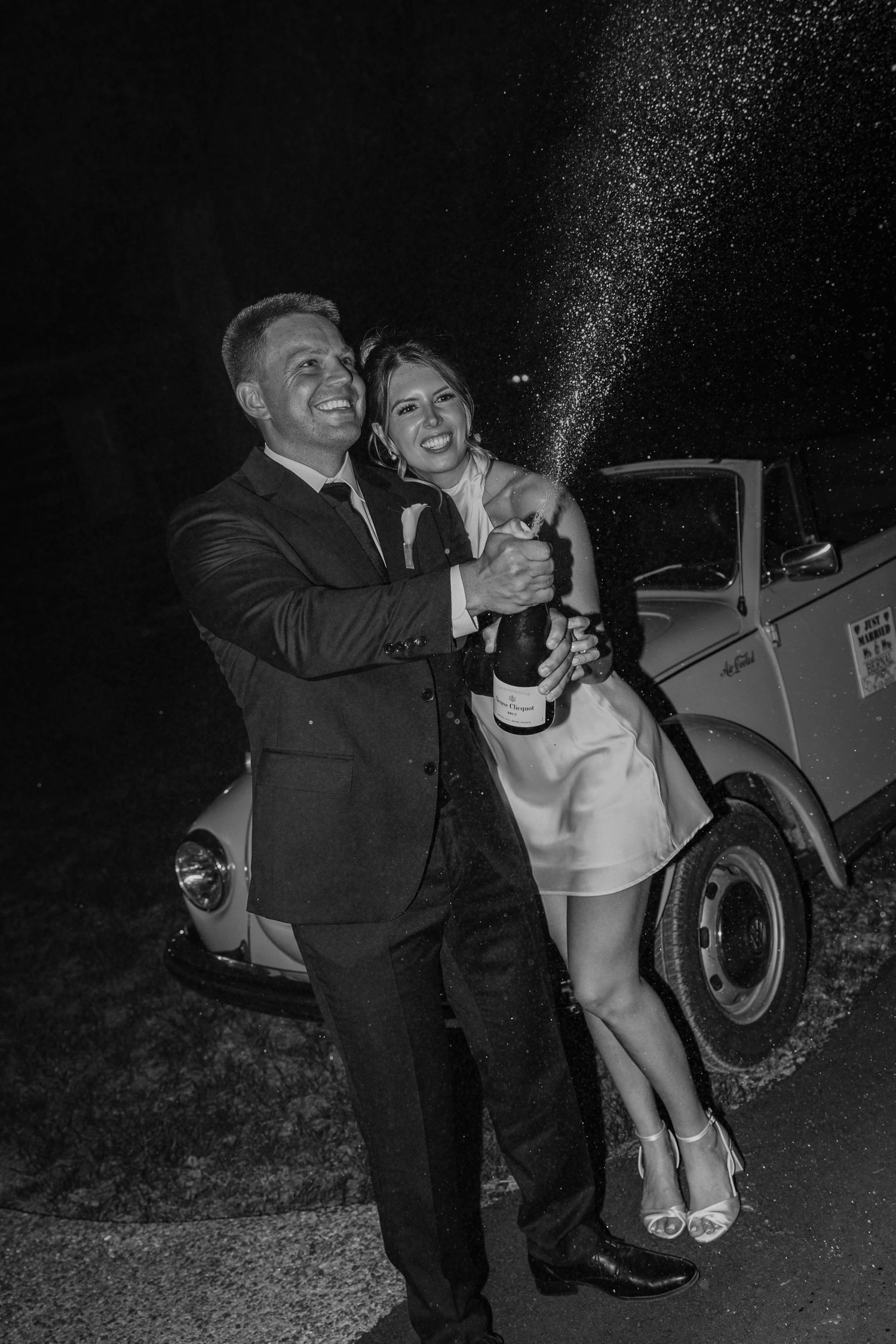 Birmingham Alabama Photographer capturing bride and groom popping champagne celebrating, at Iris Woods Venue in Nashville, Tennessee