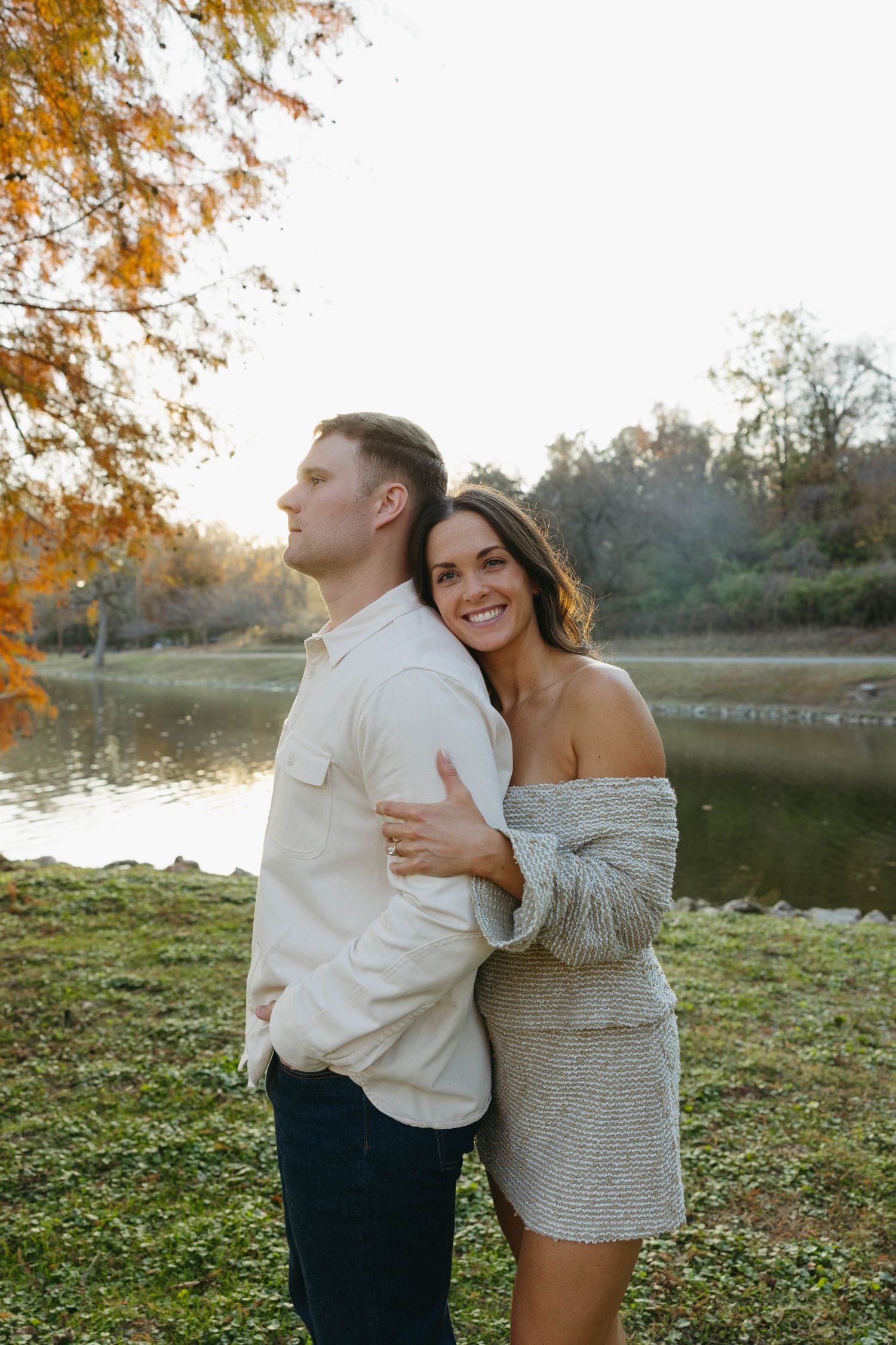Birmingham Alabama Photographer capturing an engagement session of a couple hugging in a park by a lake in Nashville Tennessee