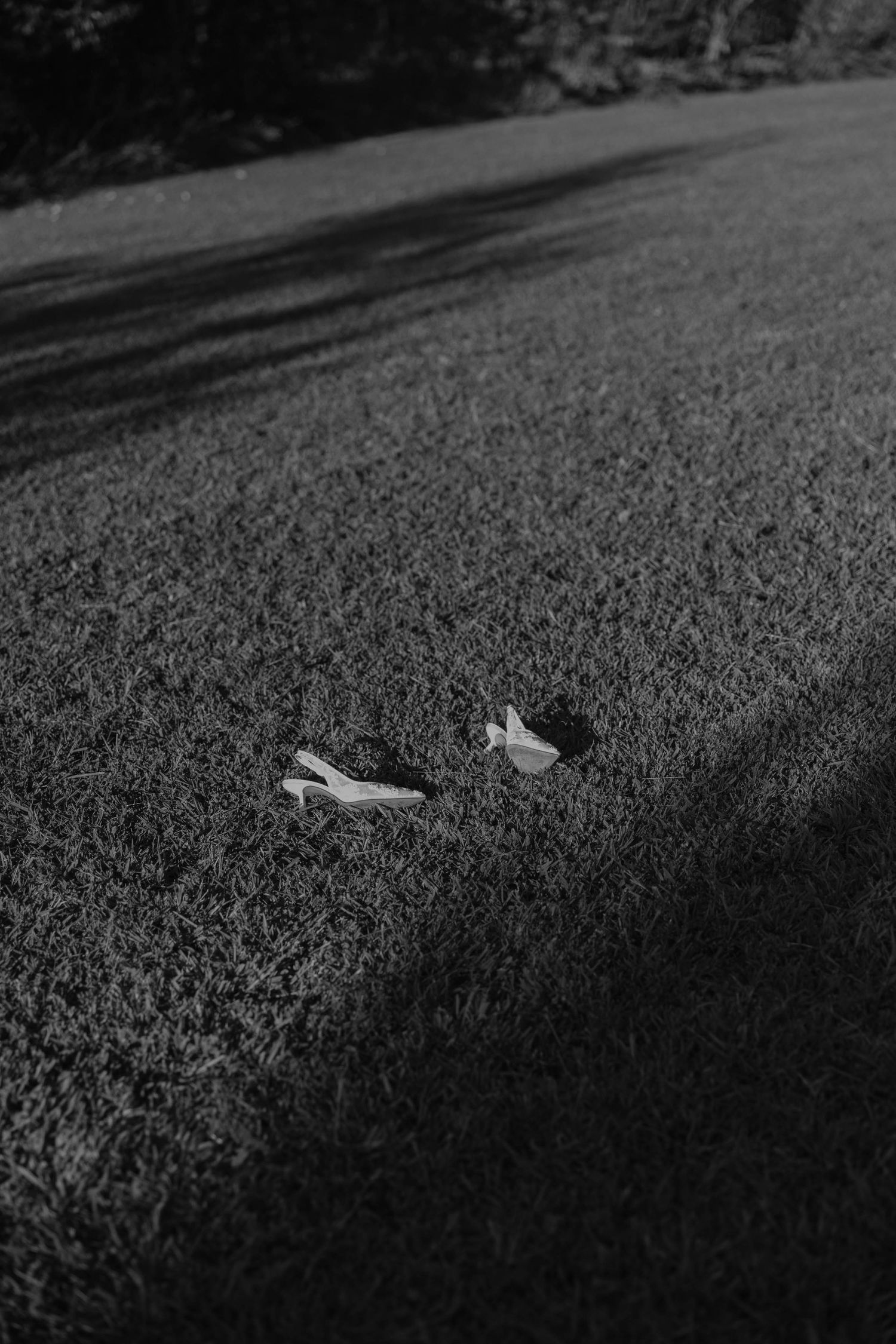 Birmingham Alabama Photographer capturing bride's shoes laying in a field, at Iris Woods Venue in Nashville, Tennessee
