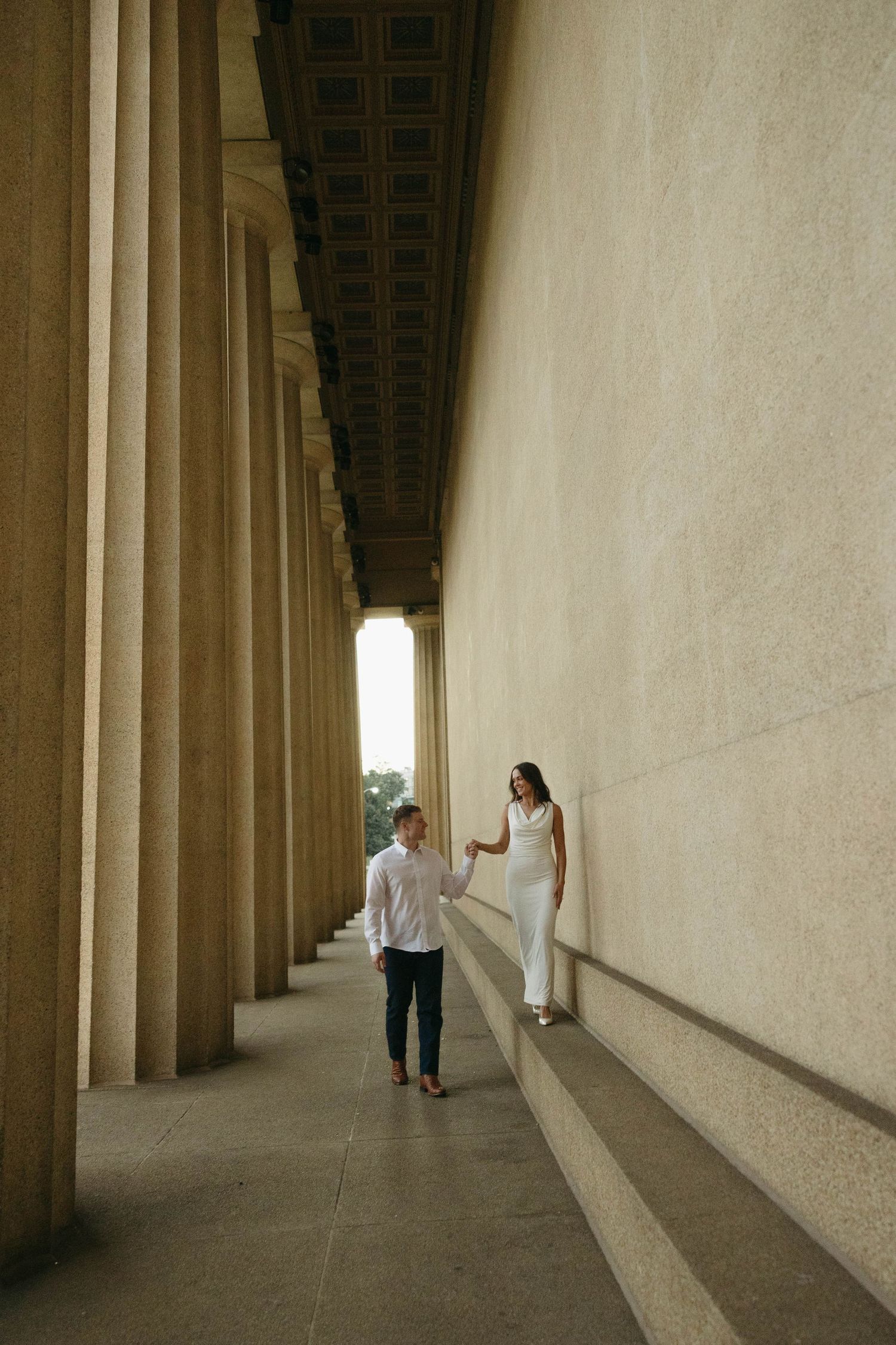 Birmingham Alabama Photographer capturing an engagement session of a couple slowly walking in Nashville Tennessee at the Parthenon