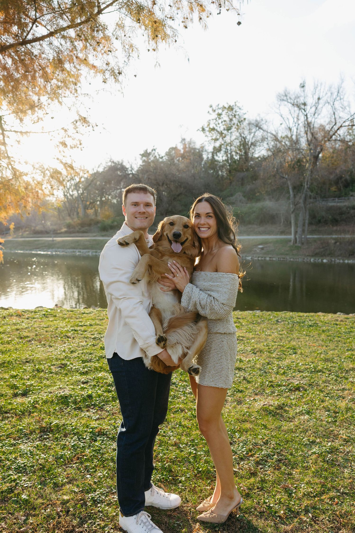 Birmingham Alabama Photographer capturing an engagement session of a couple hugging a golden retriever in a park in Nashville Tennessee