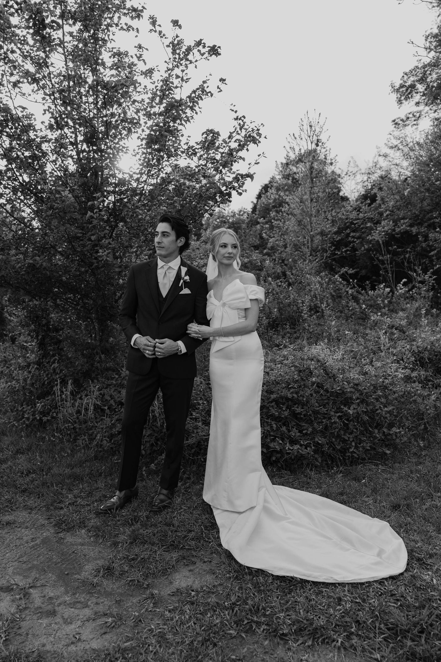 Birmingham Alabama Photographer capturing bride and groom posing, in a field, at Iris Woods Venue in Nashville, Tennessee