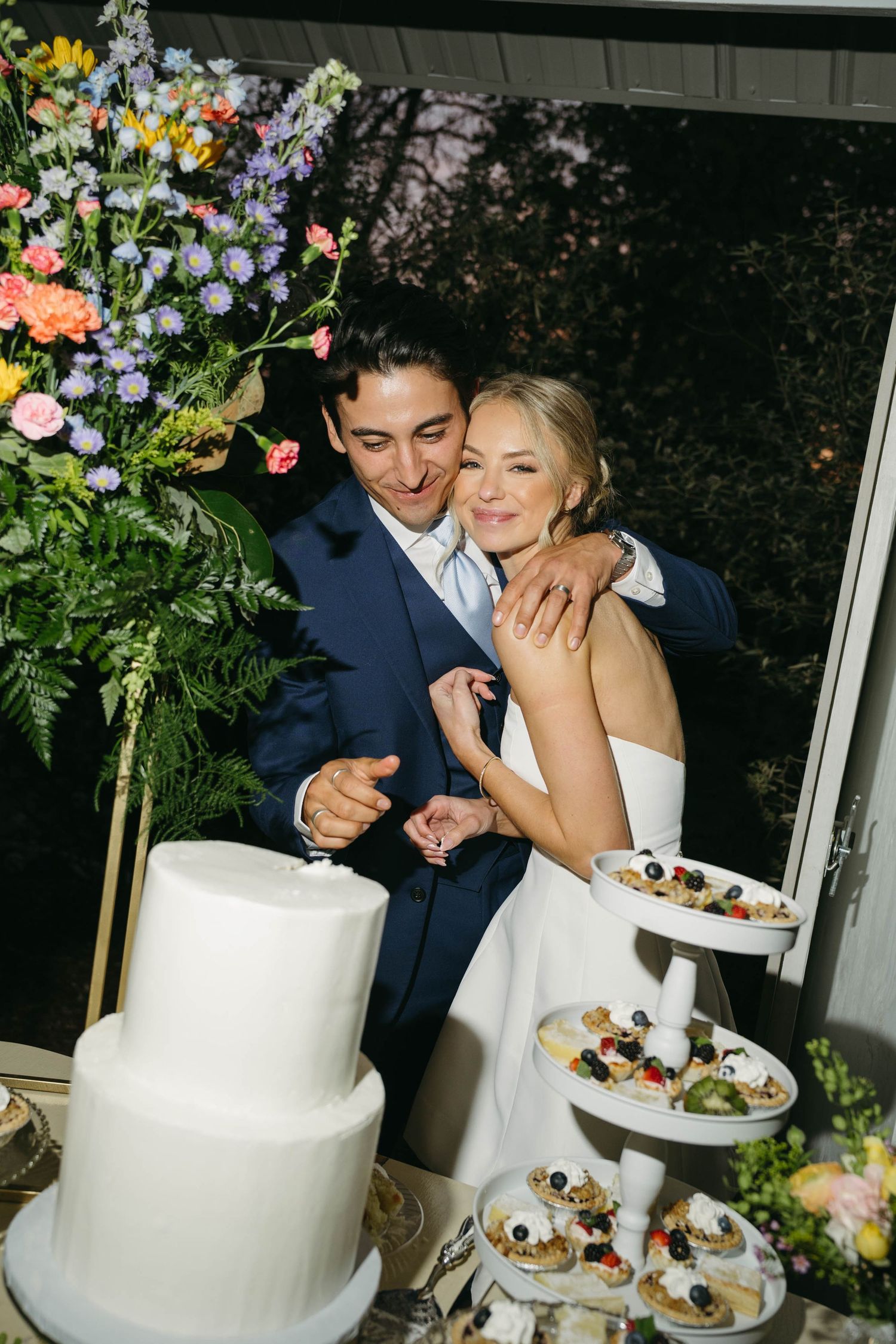 Birmingham Alabama Photographer capturing Bride and groom cutting their cake, at iris woods wedding venue in Nashville Tennessee