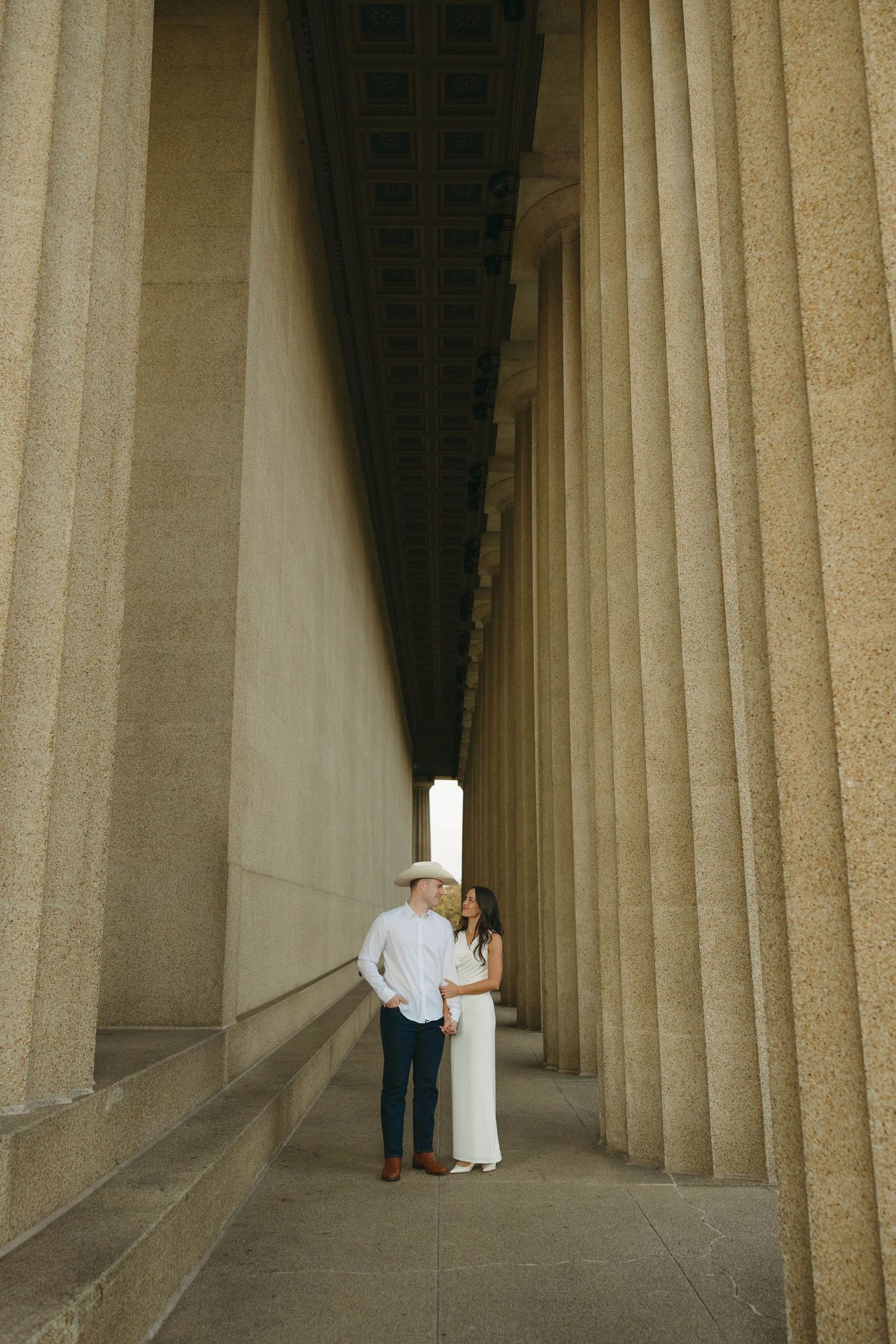 Birmingham Alabama Photographer capturing an engagement session of a couple smiling with cowboy hat in Nashville Tennessee at the Parthenon