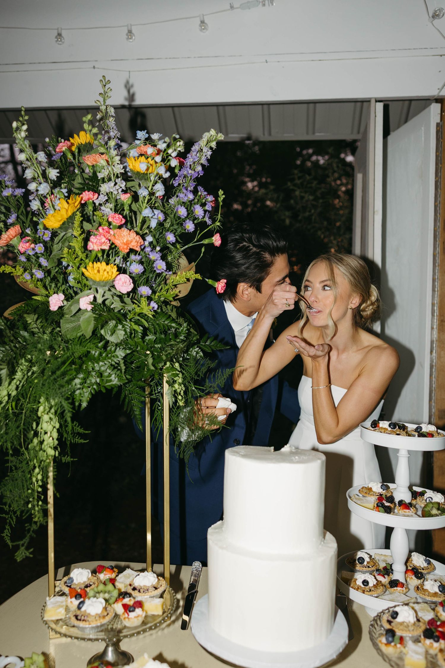 Birmingham Alabama Photographer capturing Bride and groom cutting their cake, at iris woods wedding venue in Nashville Tennessee