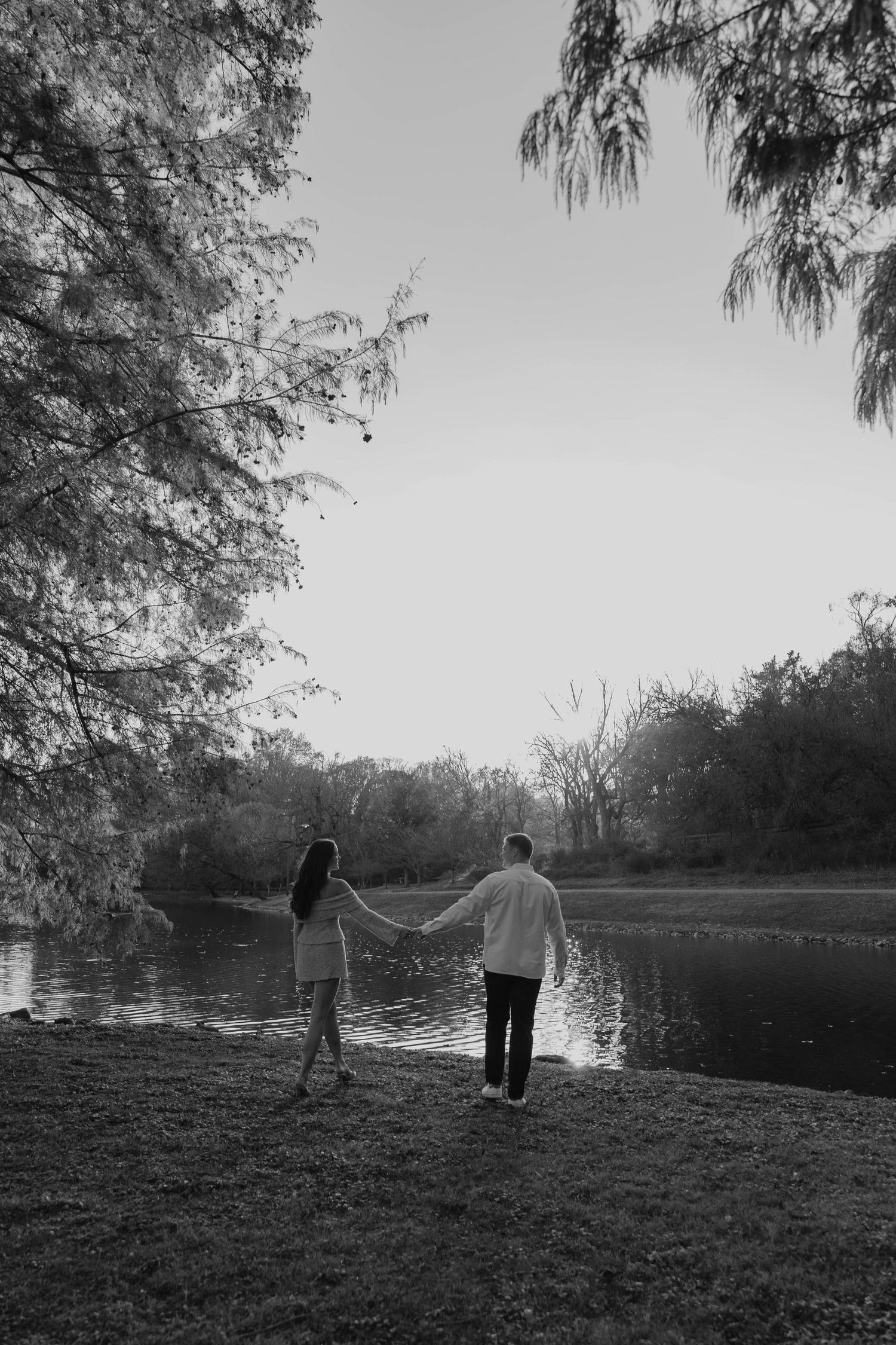 Birmingham Alabama Photographer capturing an engagement session of a couple walking in a park by a lake in Nashville Tennessee