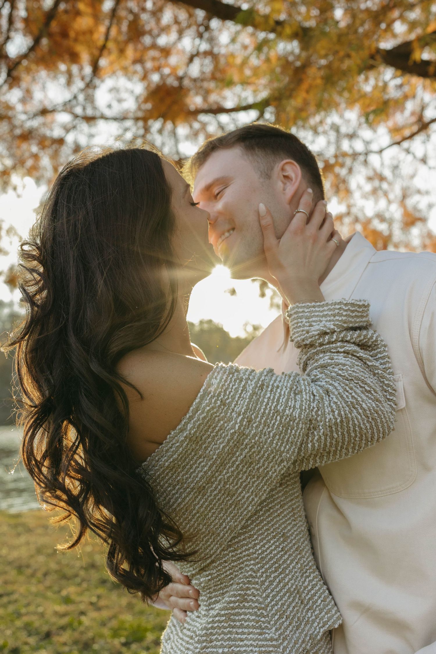 Birmingham Alabama Photographer capturing an engagement session of a couple kissing in a park by a lake in Nashville Tennessee