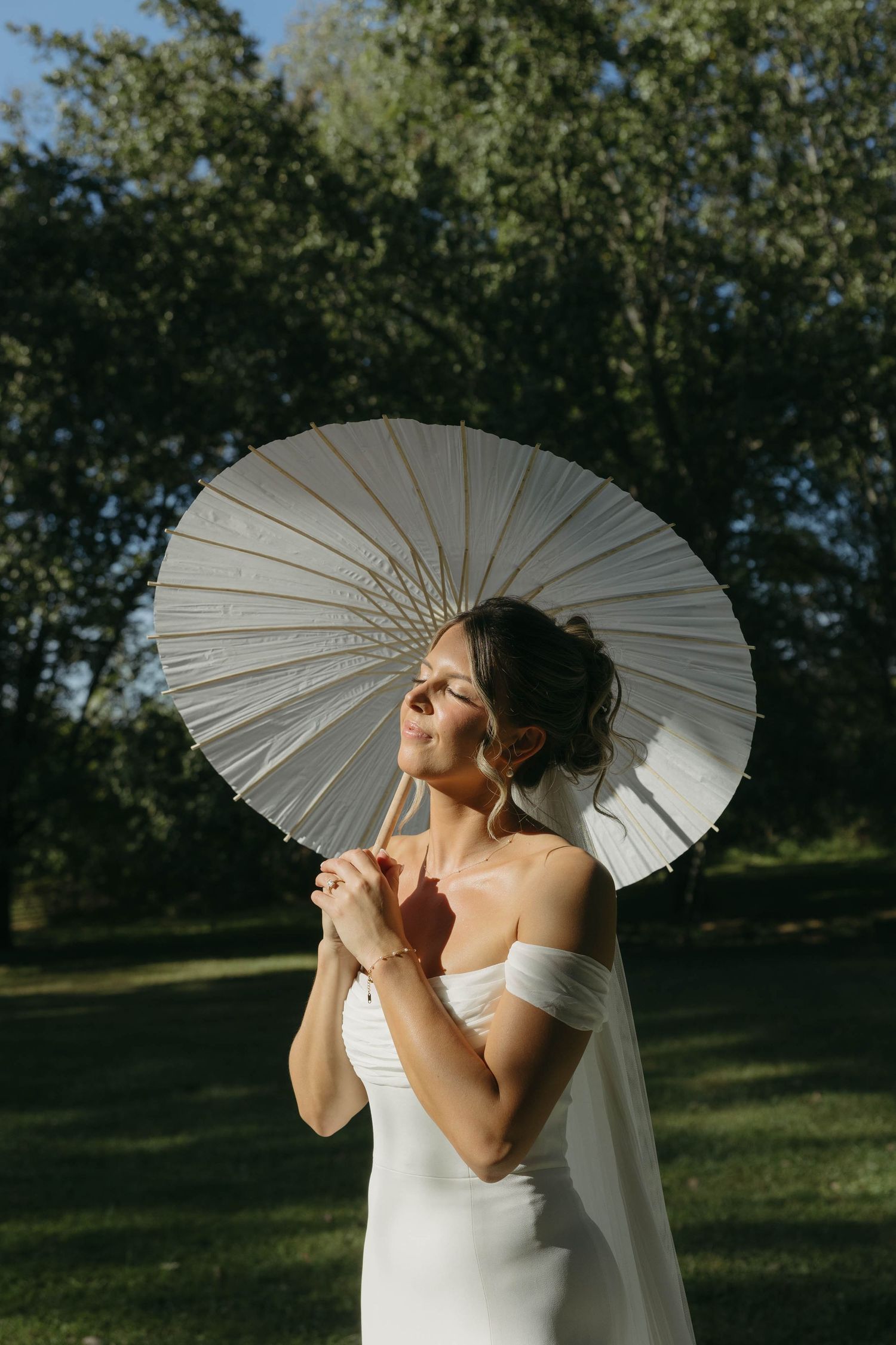 Birmingham Alabama Photographer capturing bride posing with her parasol, in the sun, at Iris Woods Venue in Nashville, Tennessee