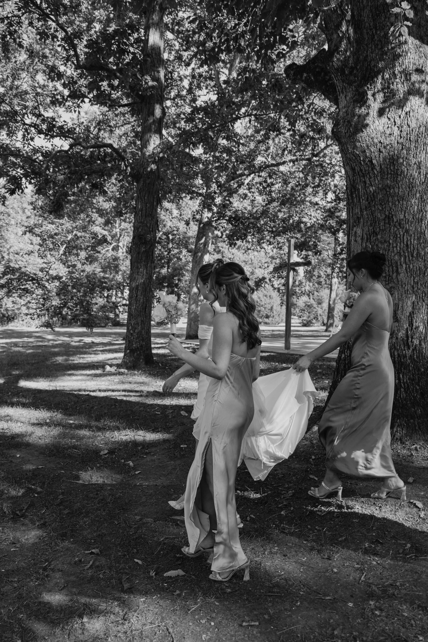 Birmingham Alabama Photographer capturing bride and bridesmaids walking in a field, at Iris Woods Venue in Nashville, Tennessee
