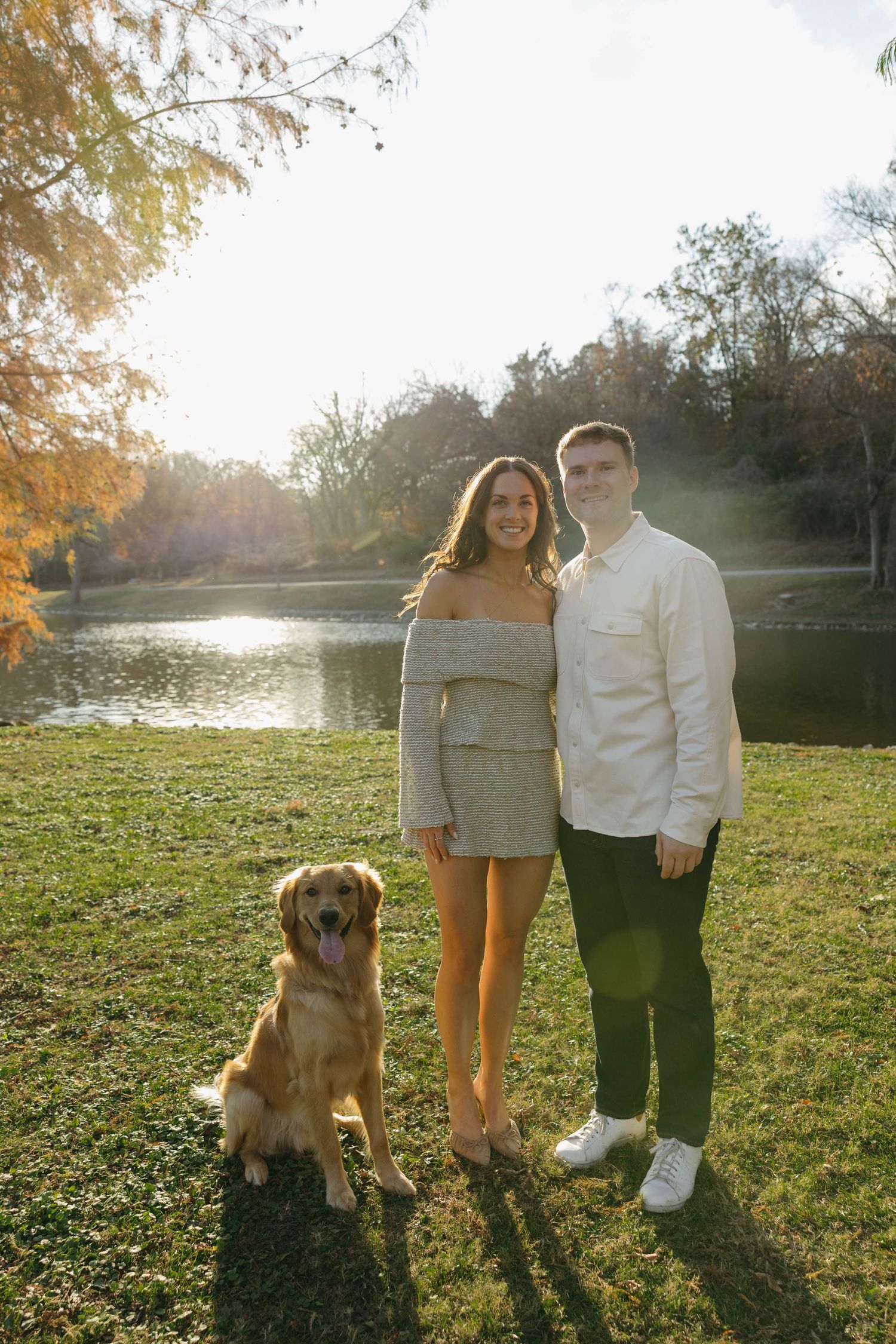 Birmingham Alabama Photographer capturing an engagement session of a couple posing with a golden retriever in a park in Nashville Tennessee