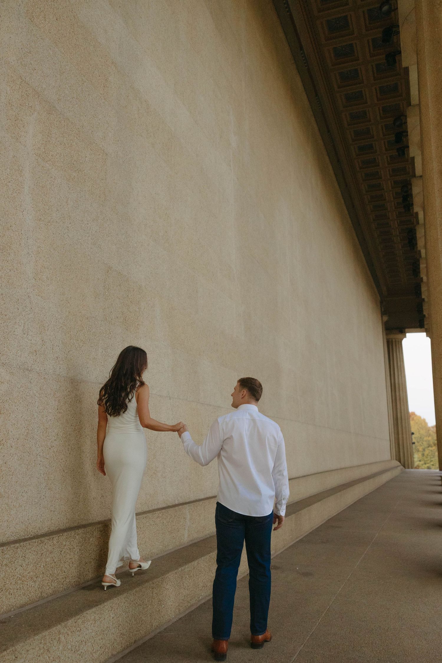 Birmingham Alabama Photographer capturing an engagement session of a couple slowly walking in Nashville Tennessee at the Parthenon
