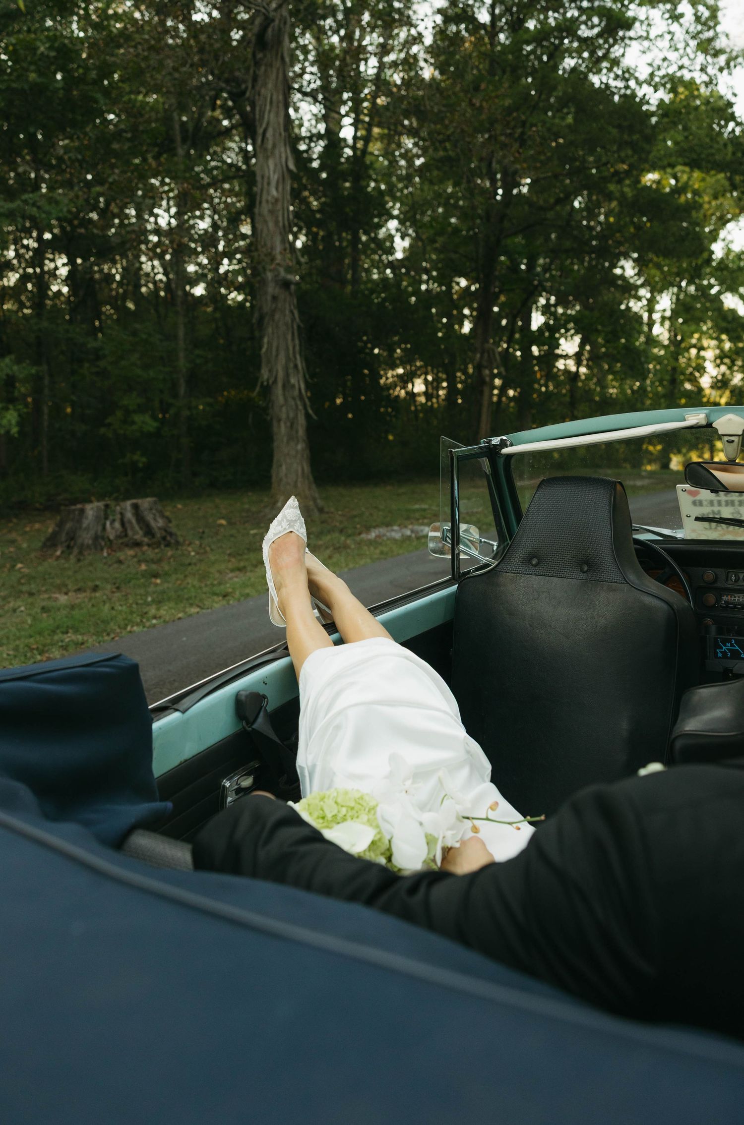 Birmingham Alabama Photographer capturing bride and groom posing in a Volkswagen beetle, at Iris Woods Venue in Nashville, Tennessee
