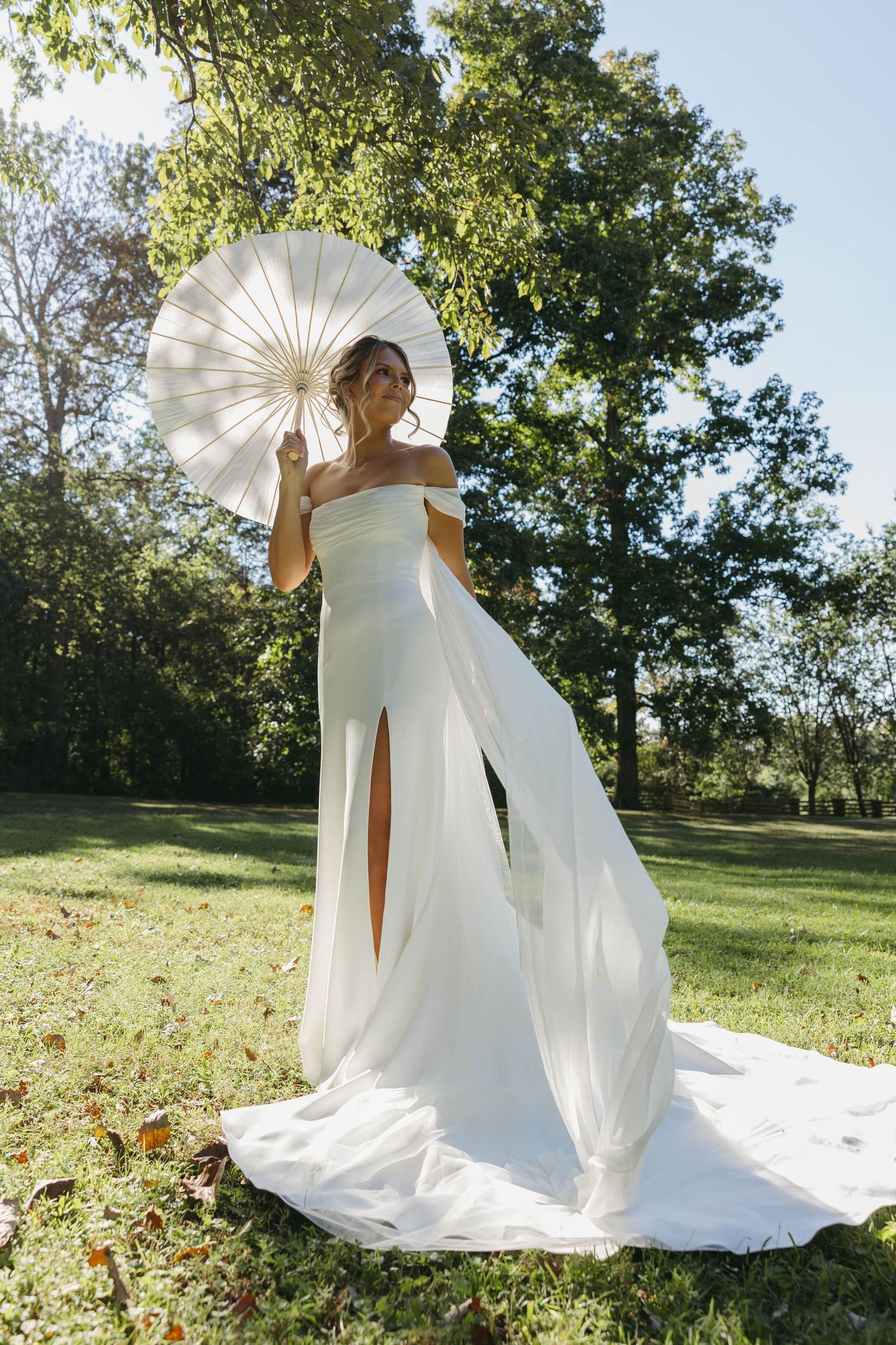 Birmingham Alabama Photographer capturing bride posing with her parasol, in the sun, at Iris Woods Venue in Nashville, Tennessee
