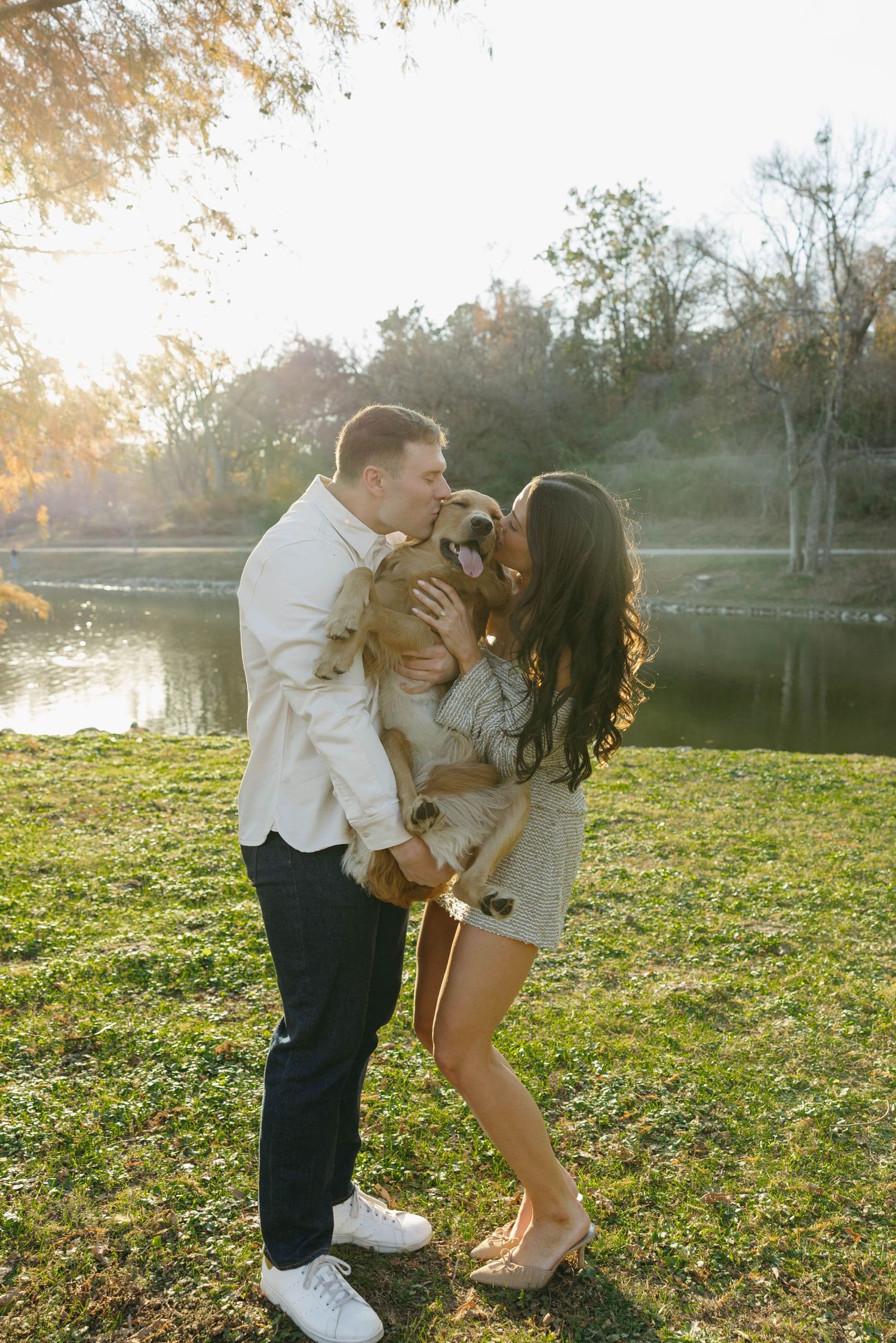 Birmingham Alabama Photographer capturing an engagement session of a couple hugging a golden retriever in a park in Nashville Tennessee