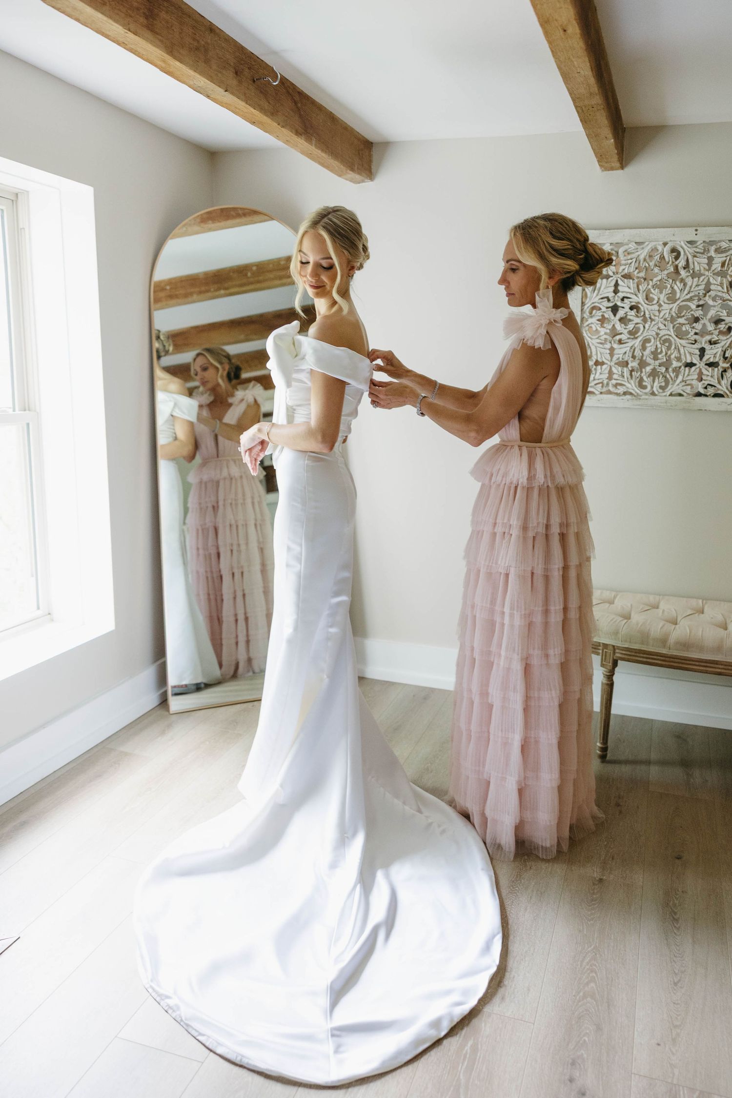 mom helping bride with dress