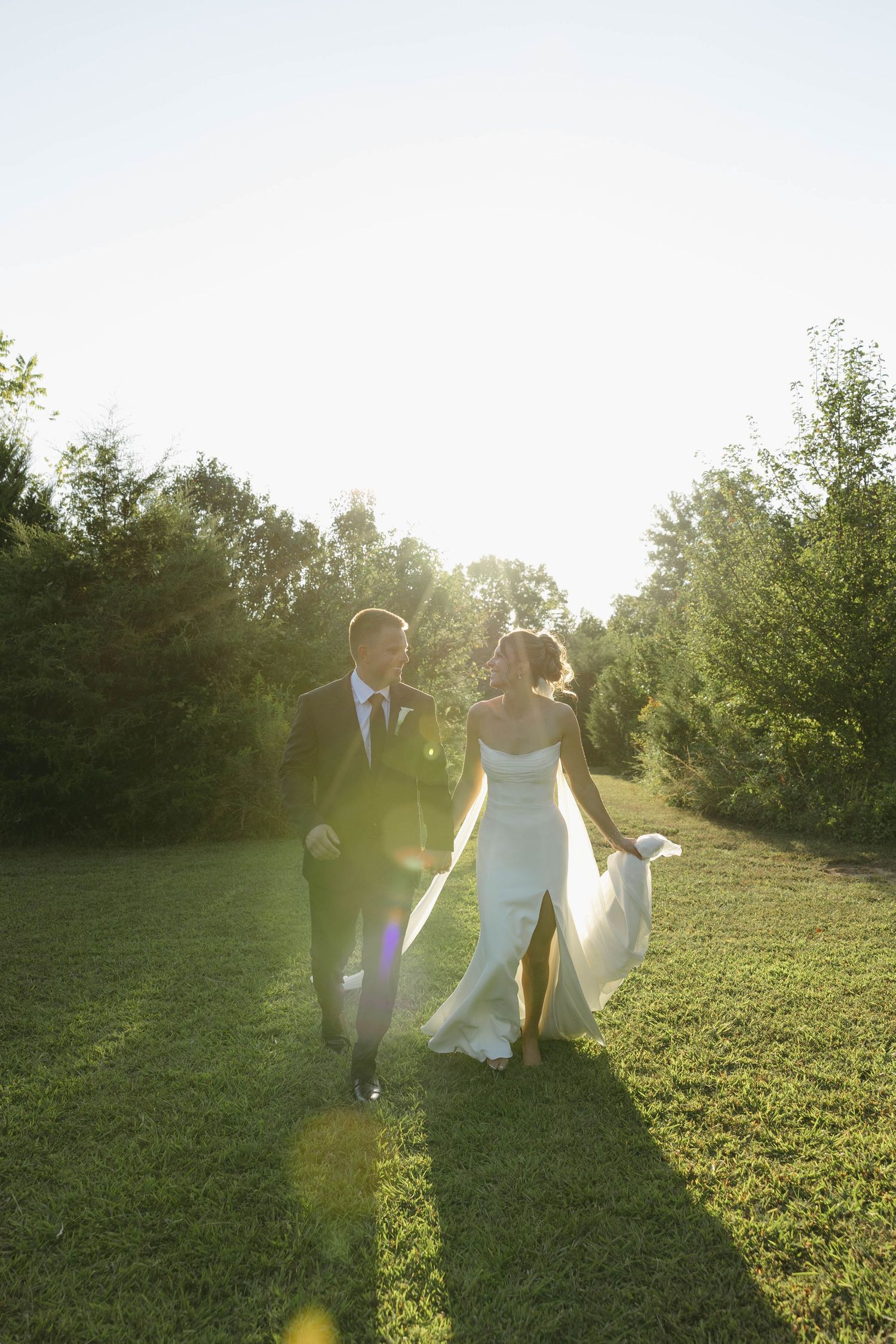 Birmingham Alabama Photographer capturing bride and groom running in a field, at Iris Woods Venue in Nashville, Tennessee