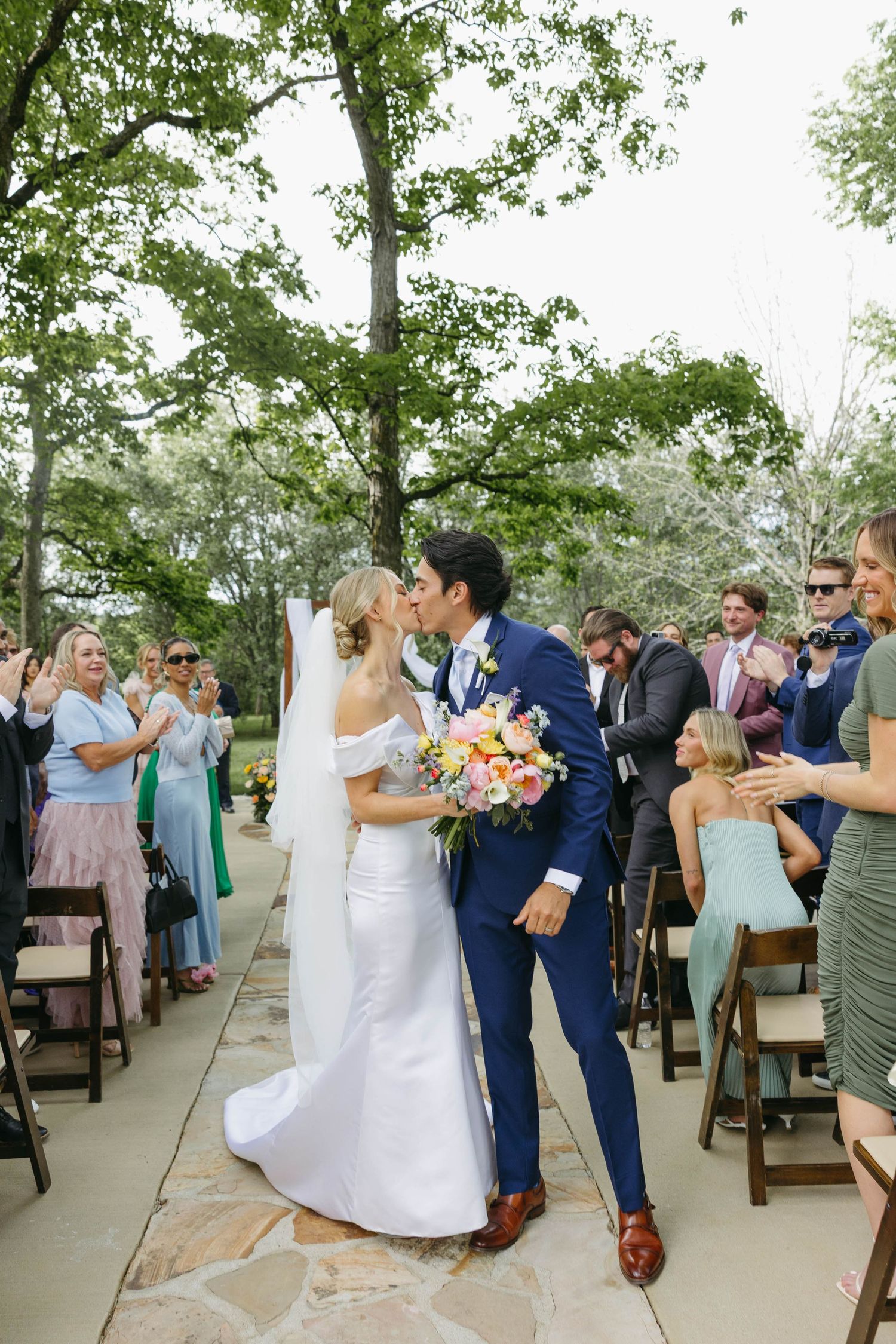 Birmingham Alabama Photographer capturing bride and groom walking down the isle kissing, at Iris Woods Venue in Nashville, Tennessee