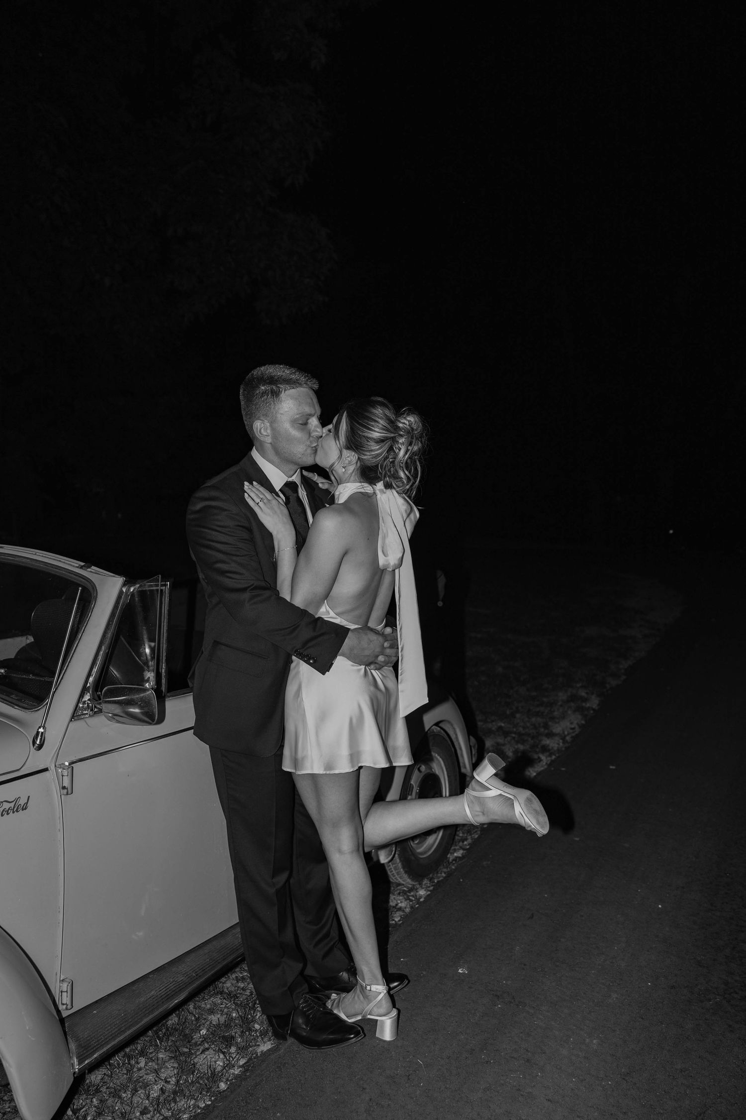 Birmingham Alabama Photographer capturing bride and groom kissing on a Volkswagen beetle, at Iris Woods Venue in Nashville, Tennessee