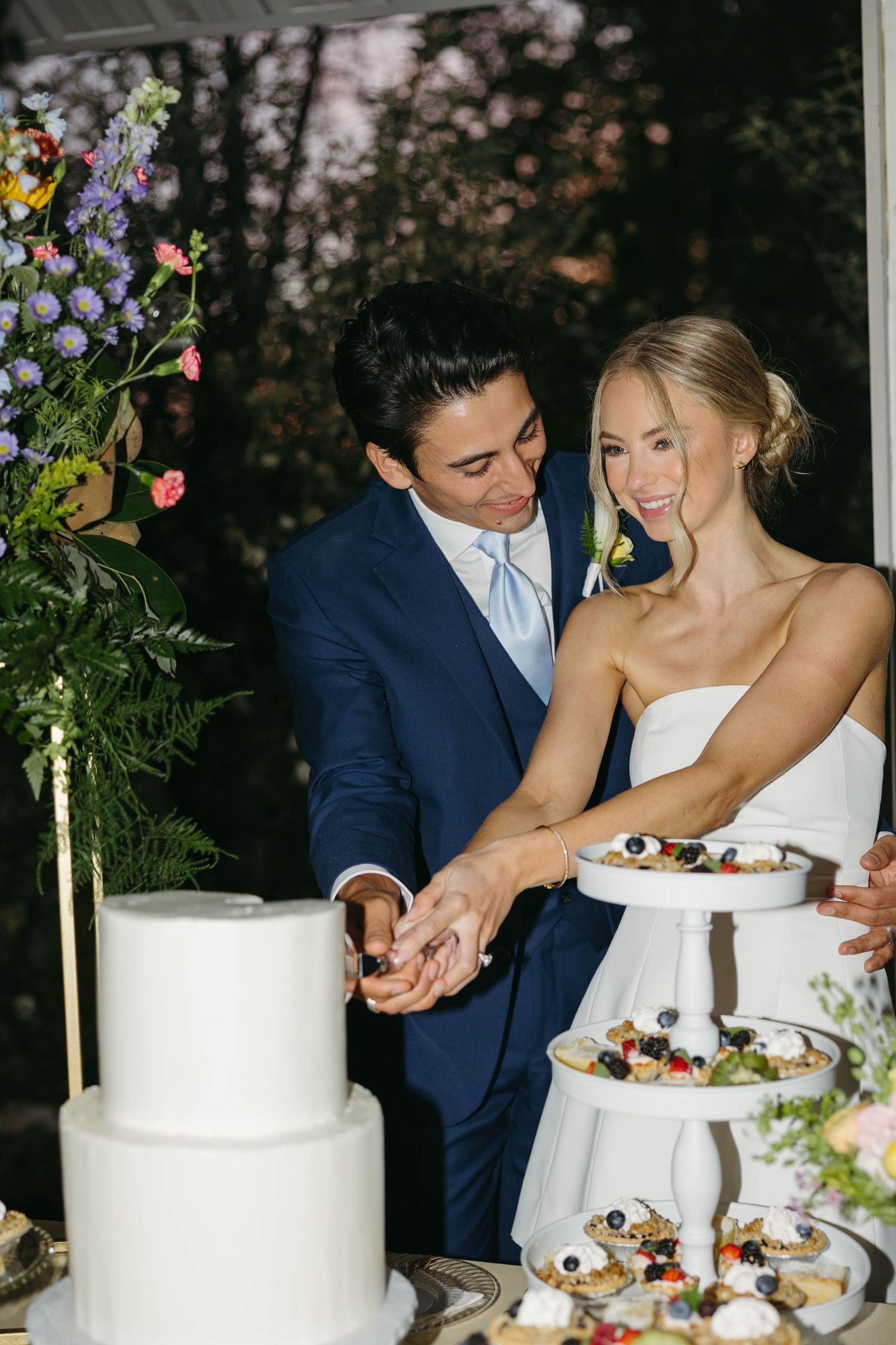 Birmingham Alabama Photographer capturing Bride and groom cutting their cake, at iris woods wedding venue in Nashville Tennessee