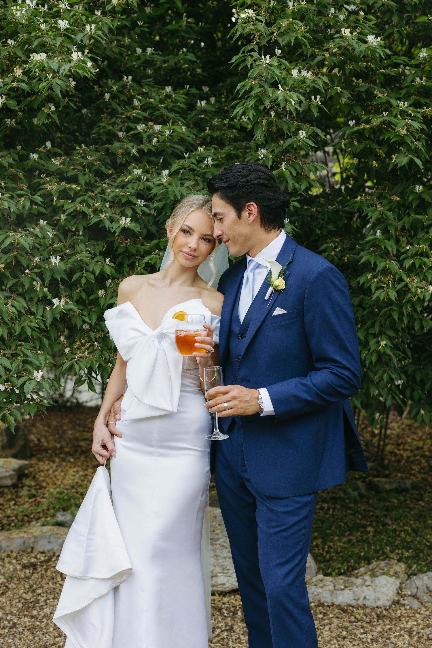 Birmingham Alabama Photographer capturing bride and groom holding wine glasses, in a field, at Iris Woods Venue in Nashville, Tennessee