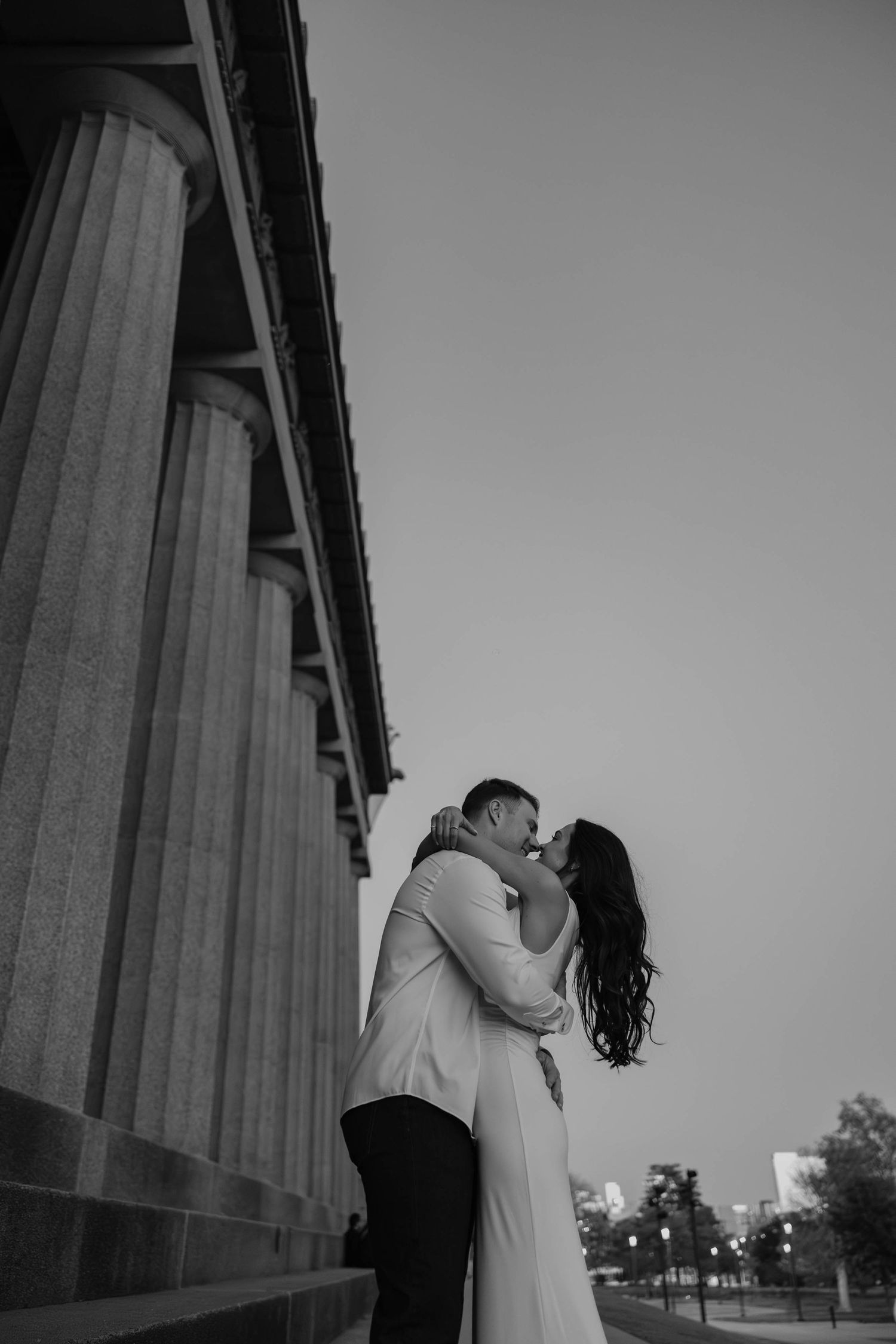Birmingham Alabama Photographer capturing an engagement session of a couple kissing and smiling  in Nashville Tennessee at the Parthenon