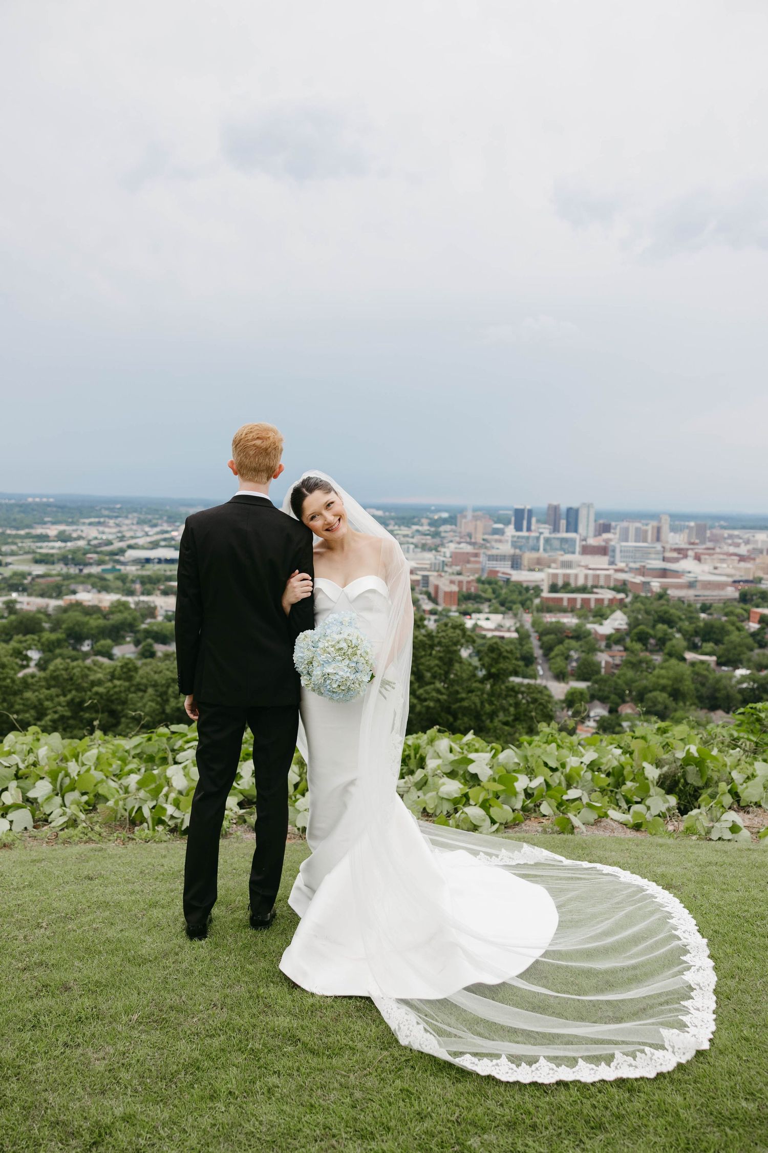 bride leaning on groom's shoulder overlooking Birmingham, Alabama
