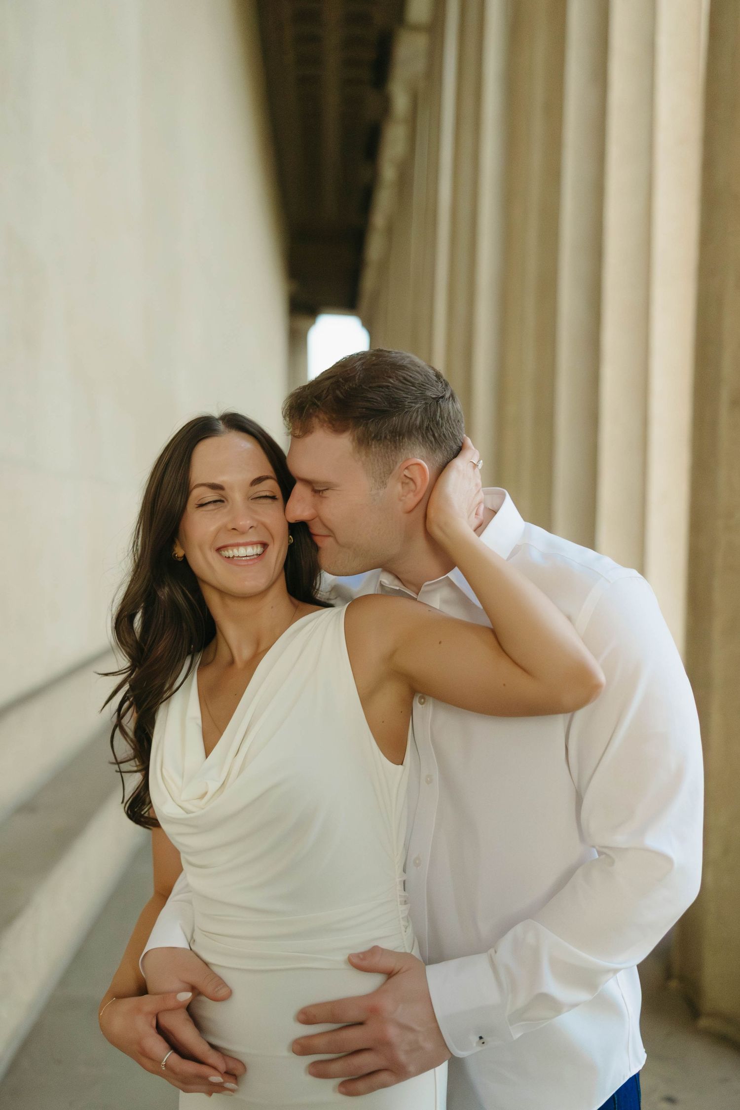 Birmingham Alabama Photographer capturing an engagement session of a couple hugging and smiling  in Nashville Tennessee at the Parthenon