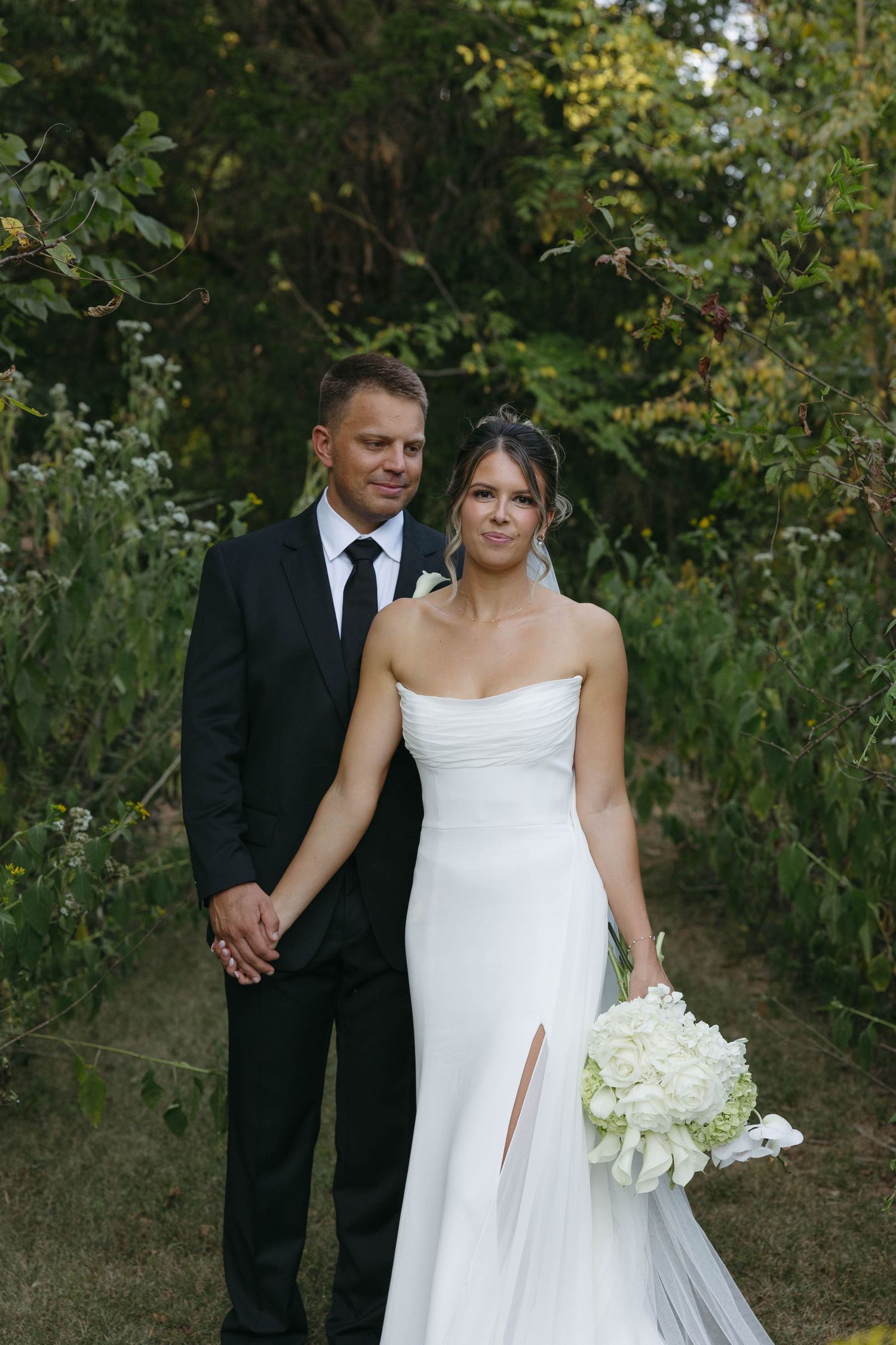 Birmingham Alabama Photographer capturing bride and groom posing in a field, at Iris Woods Venue in Nashville, Tennessee