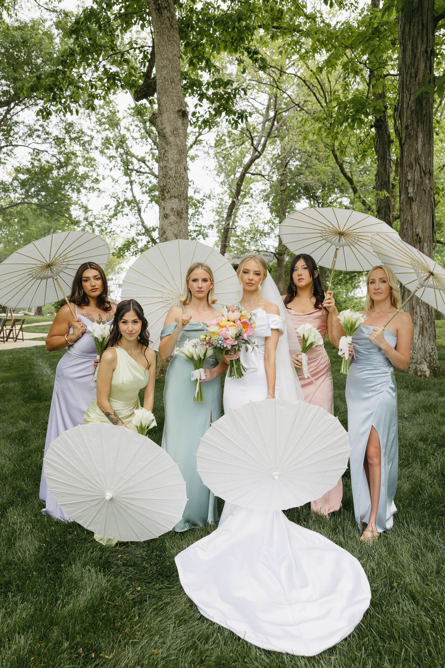 bride with bridesmaids holding parasols