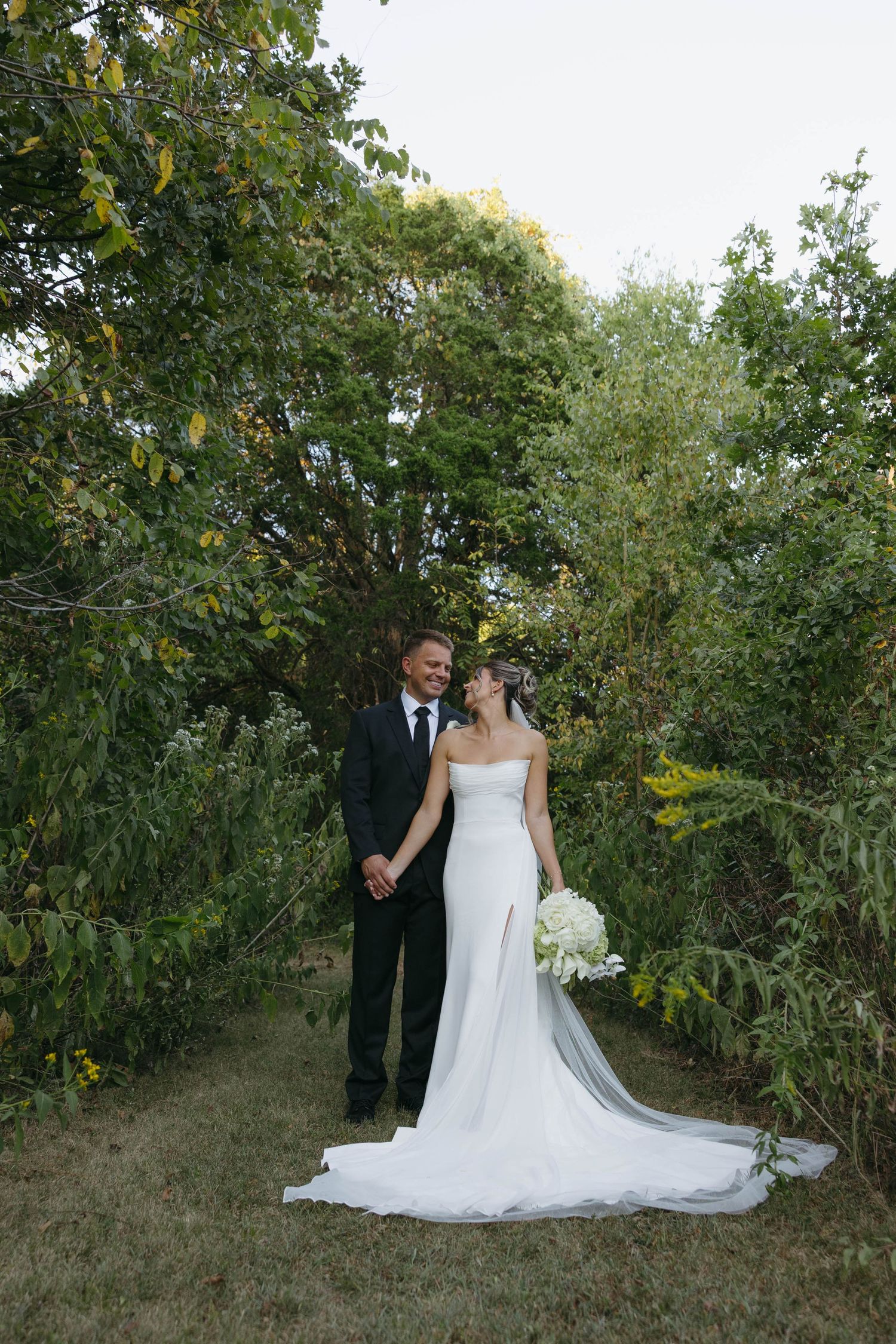 Birmingham Alabama Photographer capturing bride and groom posing in a field, at Iris Woods Venue in Nashville, Tennessee