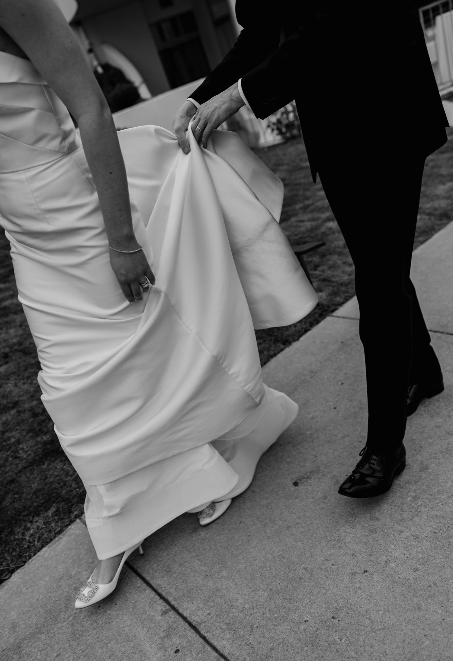 groom holding bride's dress