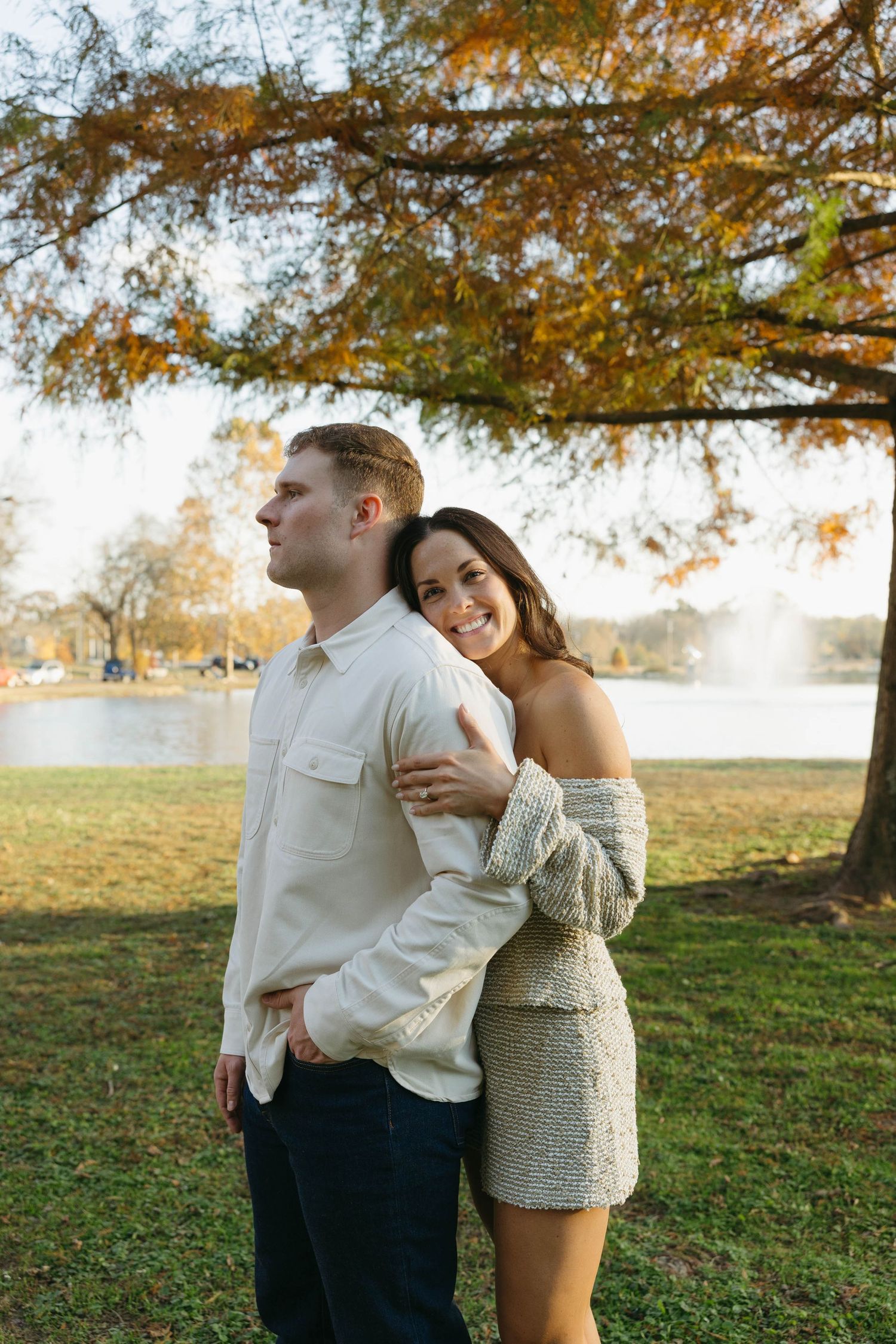 Birmingham Alabama Photographer capturing an engagement session of a couple hugging in a park by a lake in Nashville Tennessee