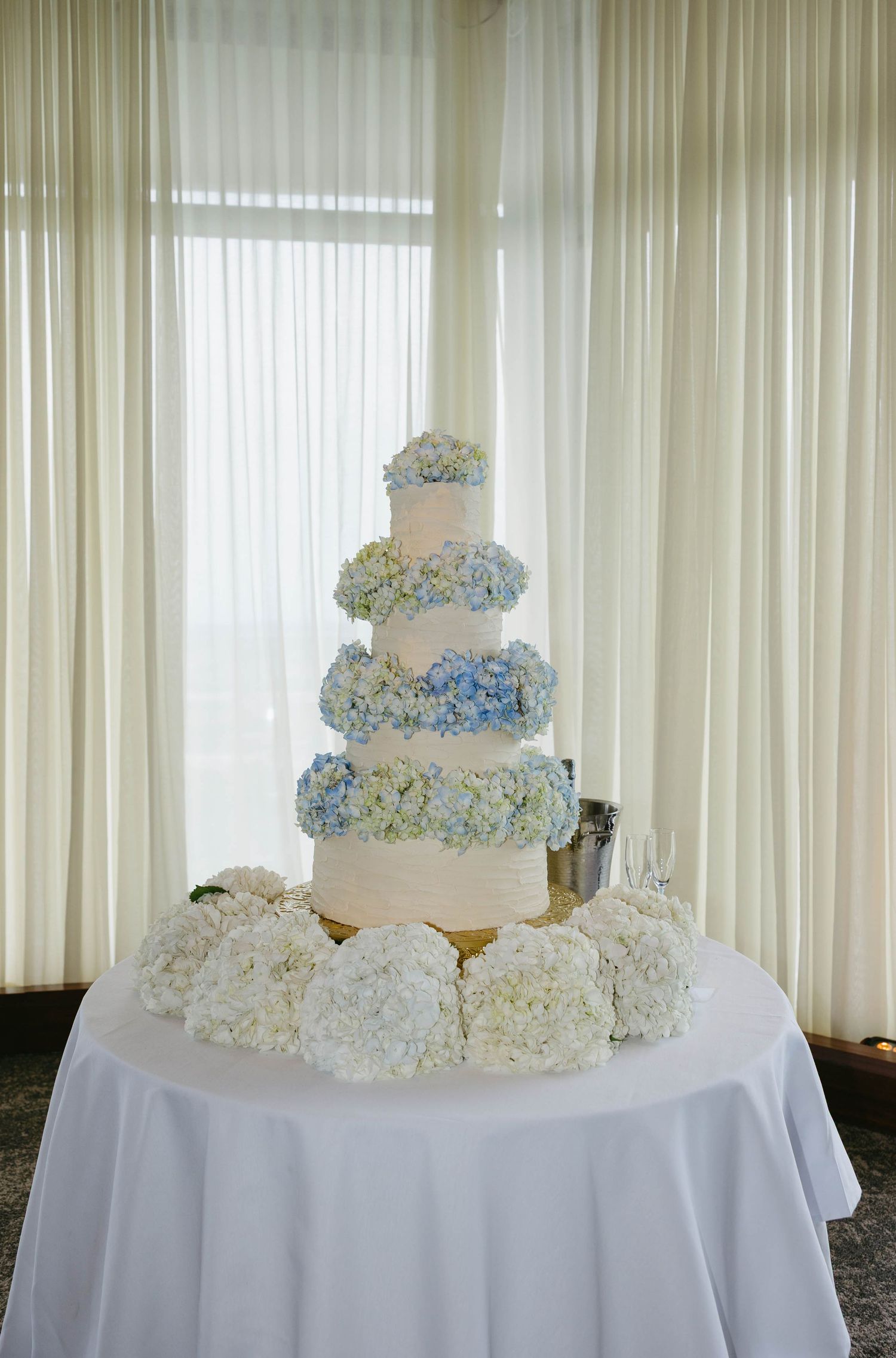 wedding cake adorned with blue hydrangeas
