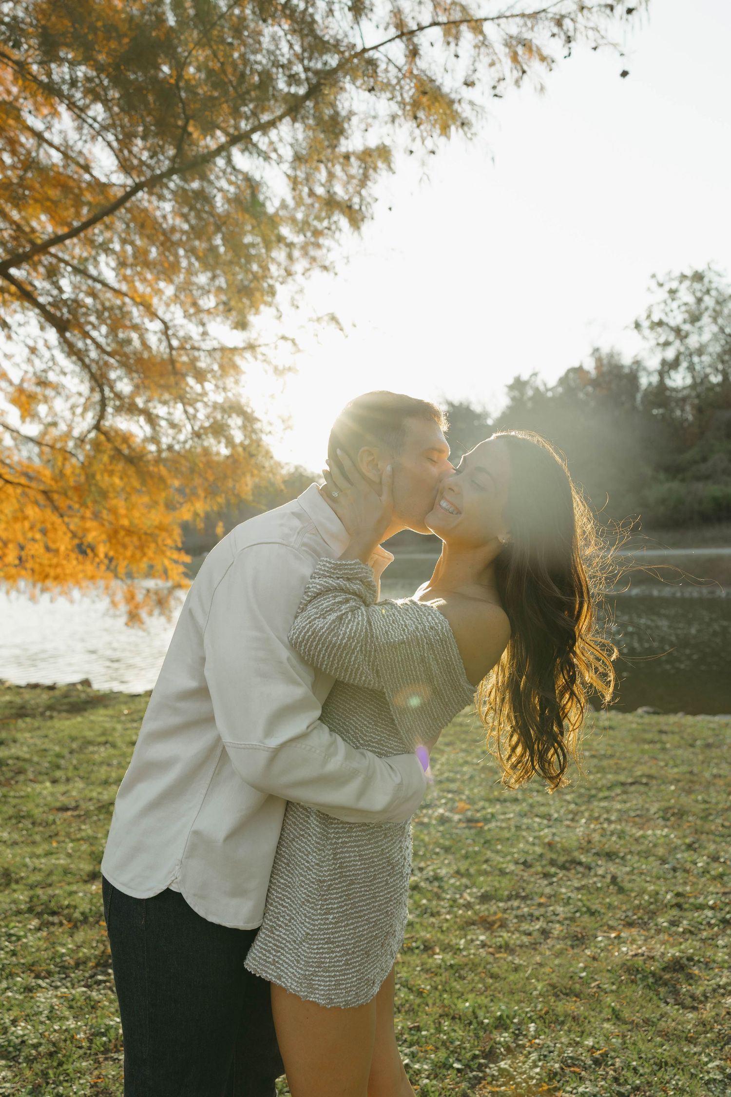 Birmingham Alabama Photographer capturing an engagement session of a couple kissing in a park by a lake in Nashville Tennessee