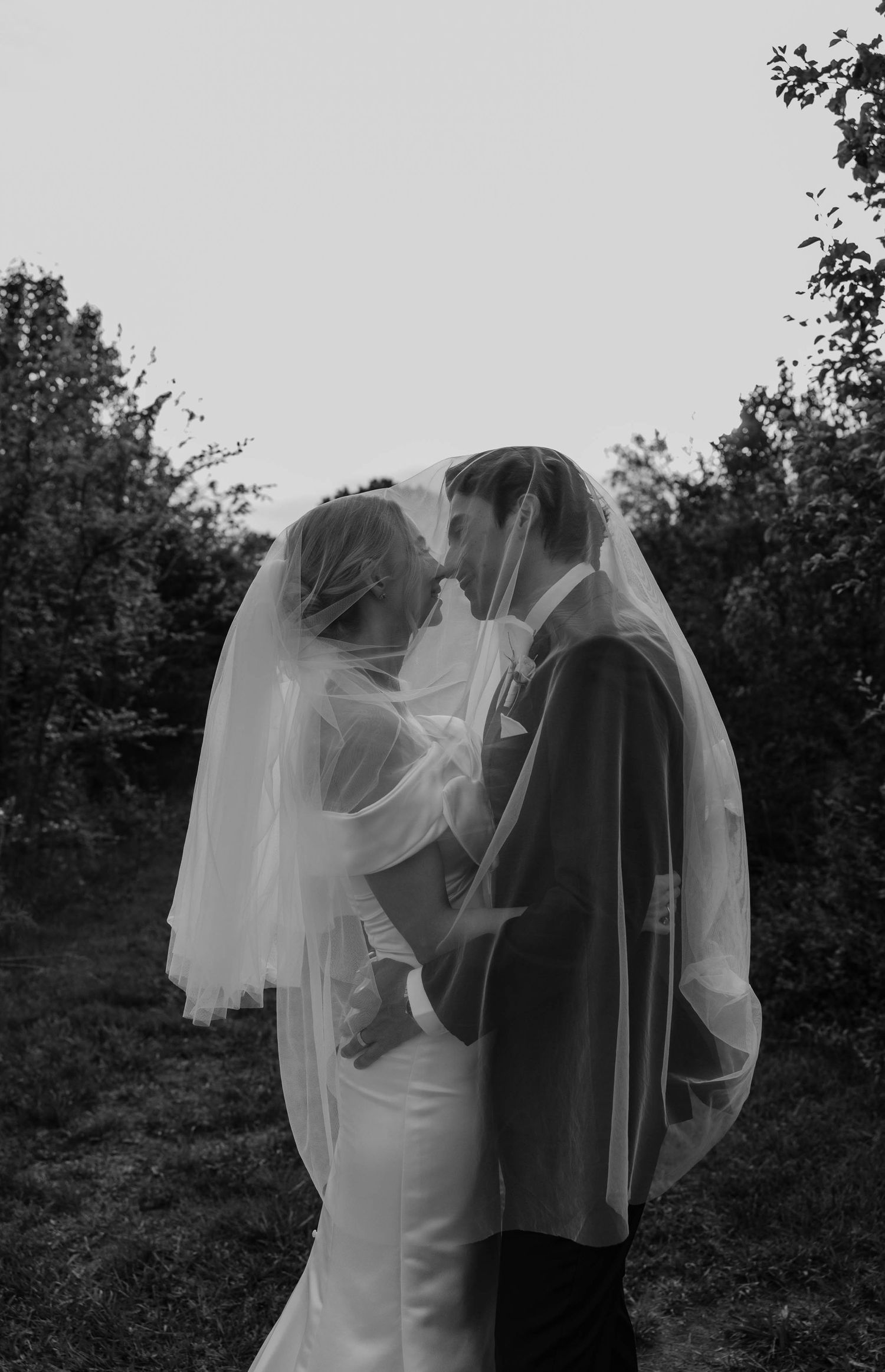 bride and groom kissing under veil