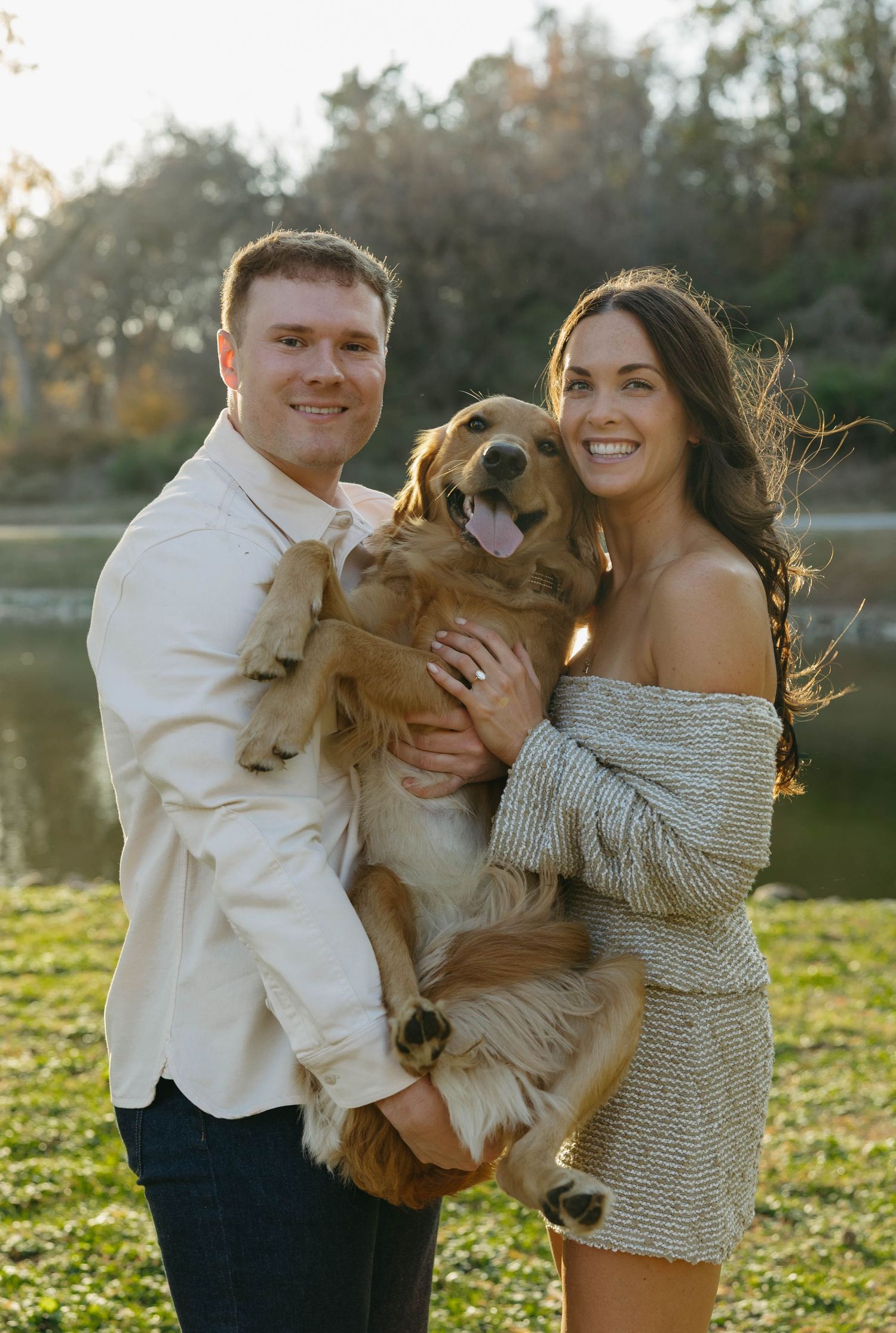 Birmingham Alabama Photographer capturing an engagement session of a couple hugging a golden retriever in a park in Nashville Tennessee