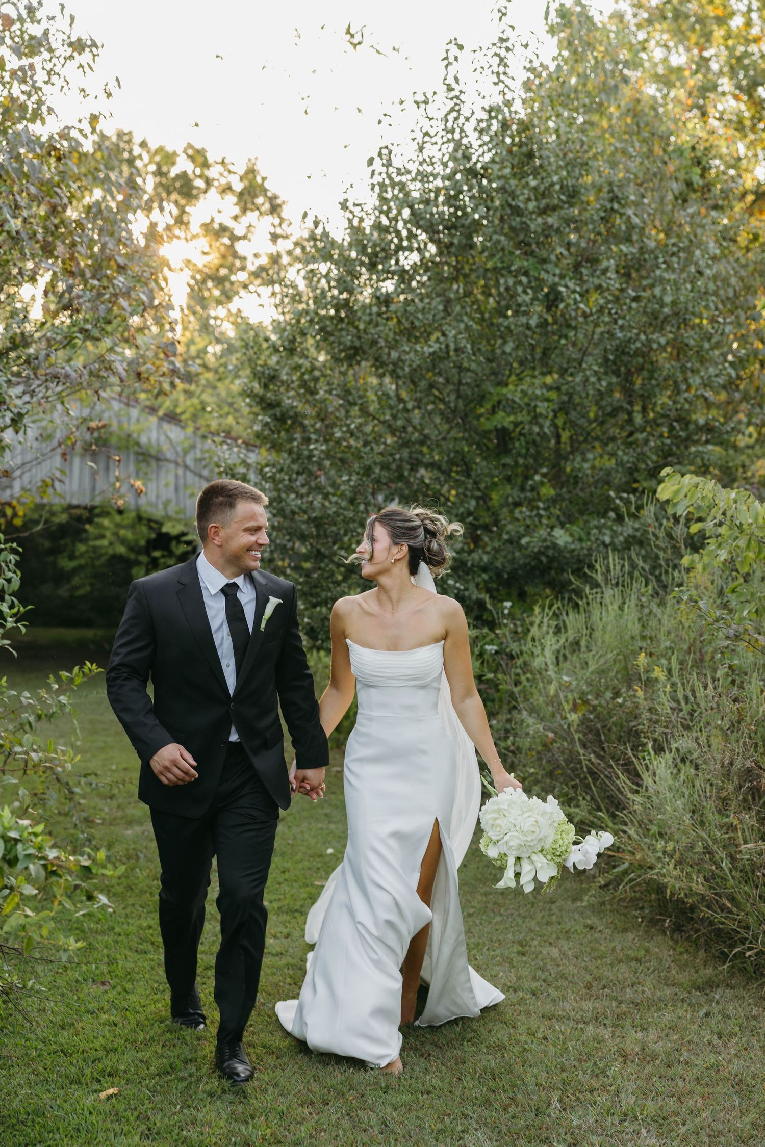 Birmingham Alabama Photographer capturing bride and groom walking in a field, at Iris Woods Venue in Nashville, Tennessee