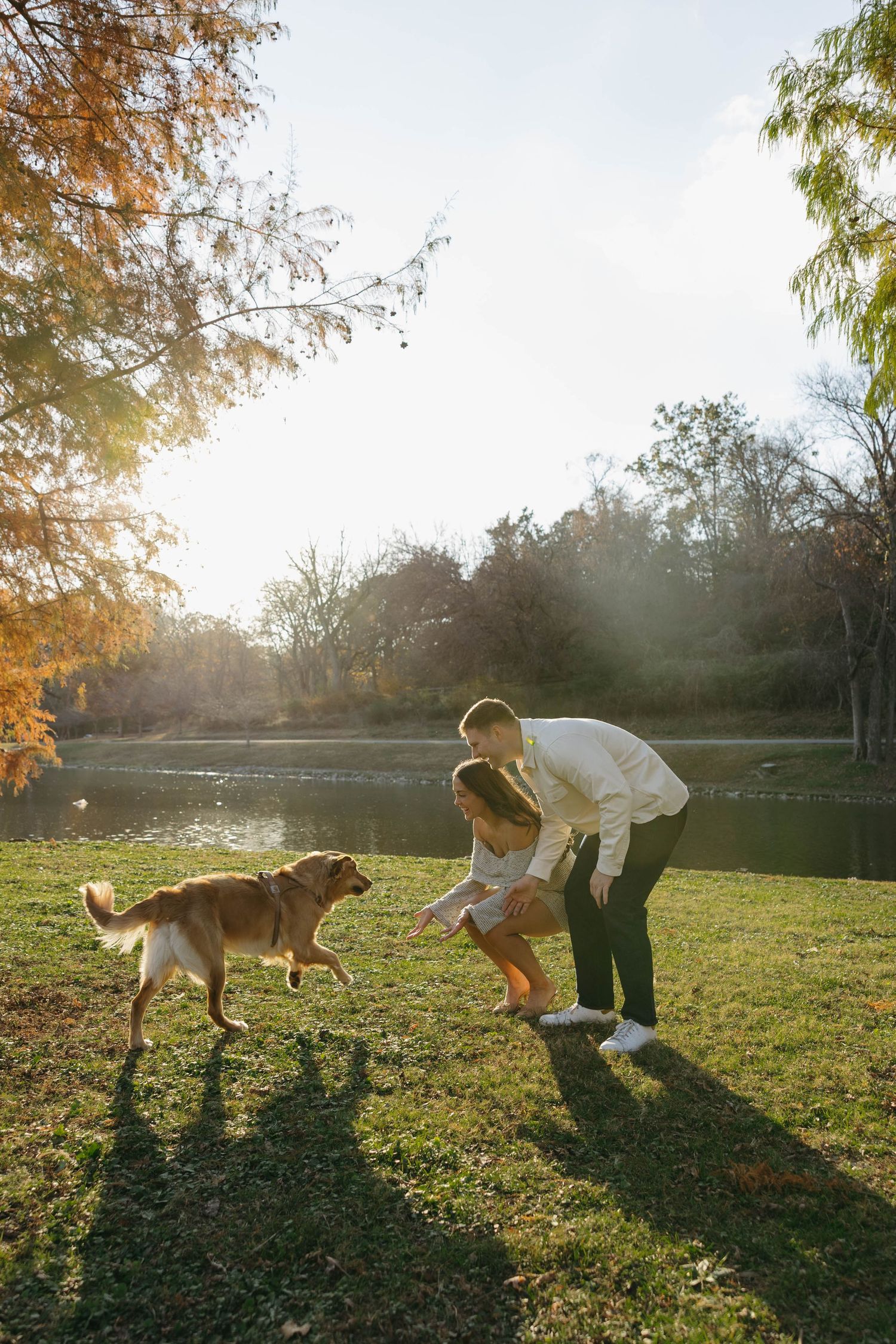 Birmingham Alabama Photographer capturing an engagement session of a couple running with golden retriever in a park in Nashville Tennessee