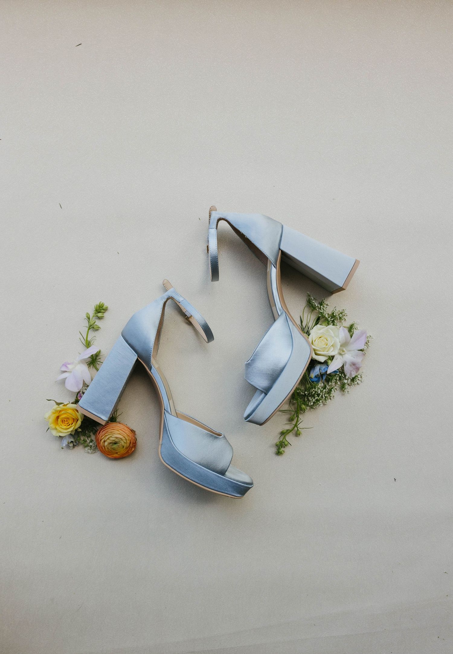 bride's shoes and floral flat lay