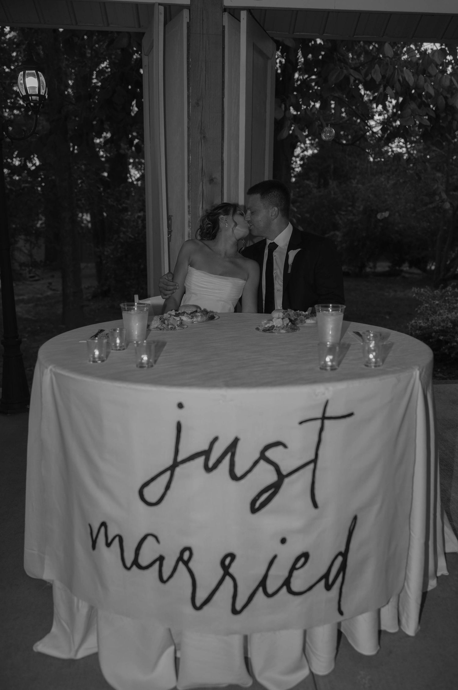 Birmingham Alabama Photographer capturing bride and groom kissing at sweetheart table, at Iris Woods Venue in Nashville, Tennessee