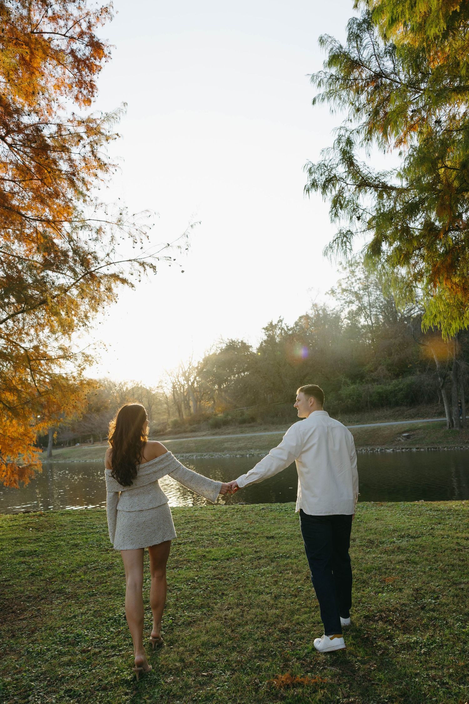 Birmingham Alabama Photographer capturing an engagement session of a couple walking in a park by a lake in Nashville Tennessee