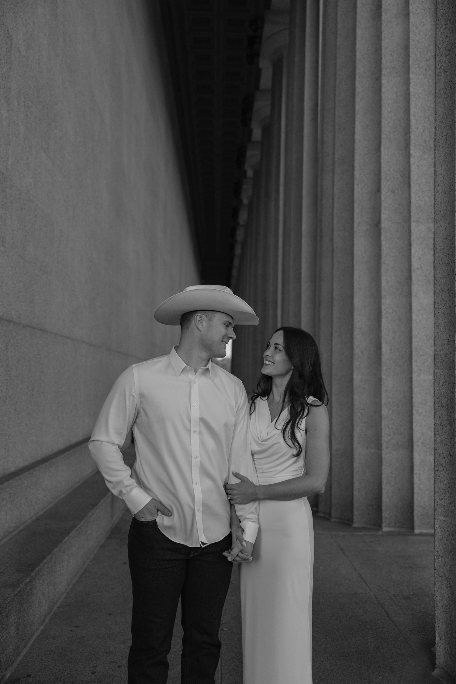 Birmingham Alabama Photographer capturing an engagement session of a couple smiling with cowboy hat in Nashville Tennessee at the Parthenon