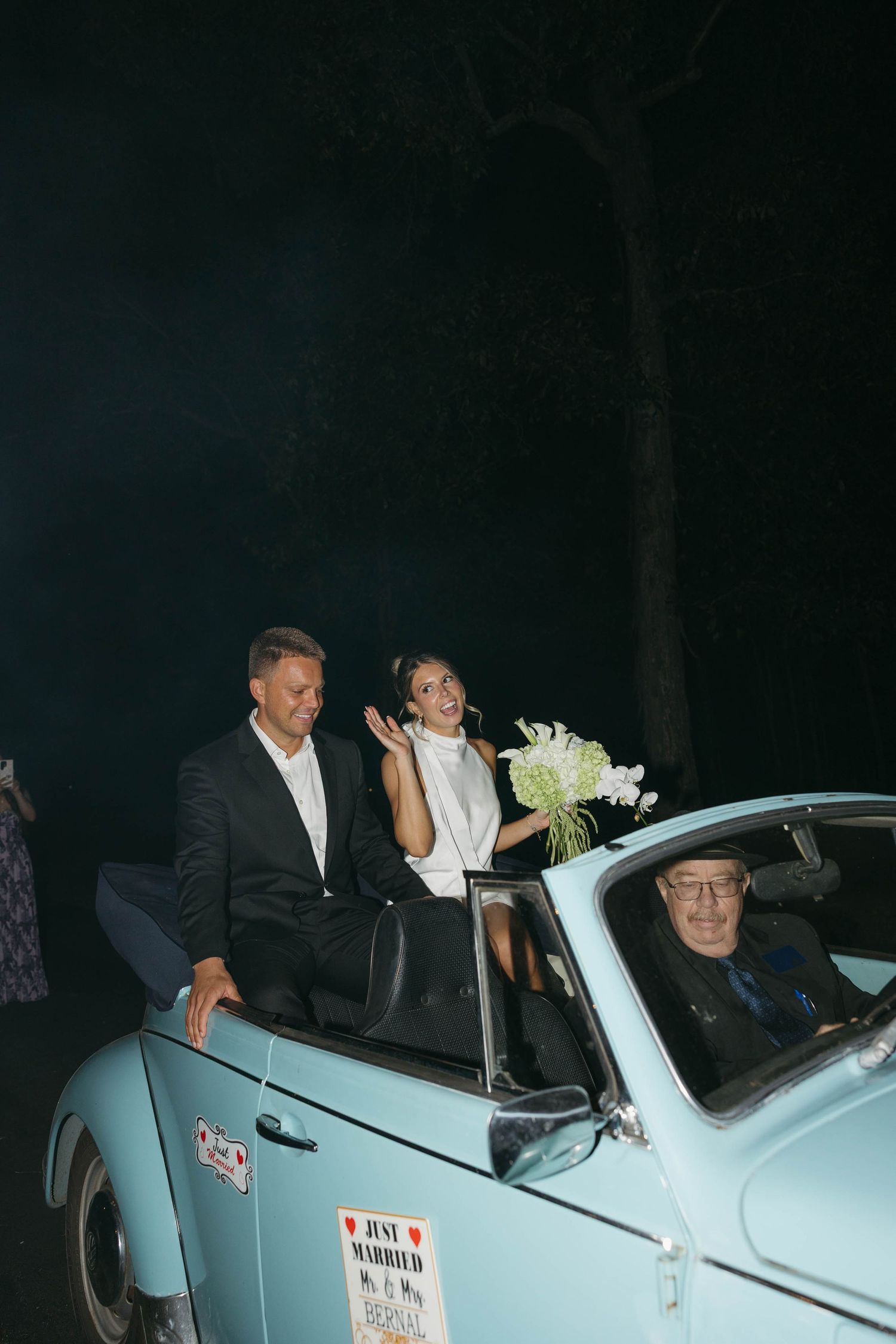 Birmingham Alabama Photographer capturing a couple waving goodbye in a Volkswagen Beetle, at Iris Woods Venue in Nashville, Tennessee