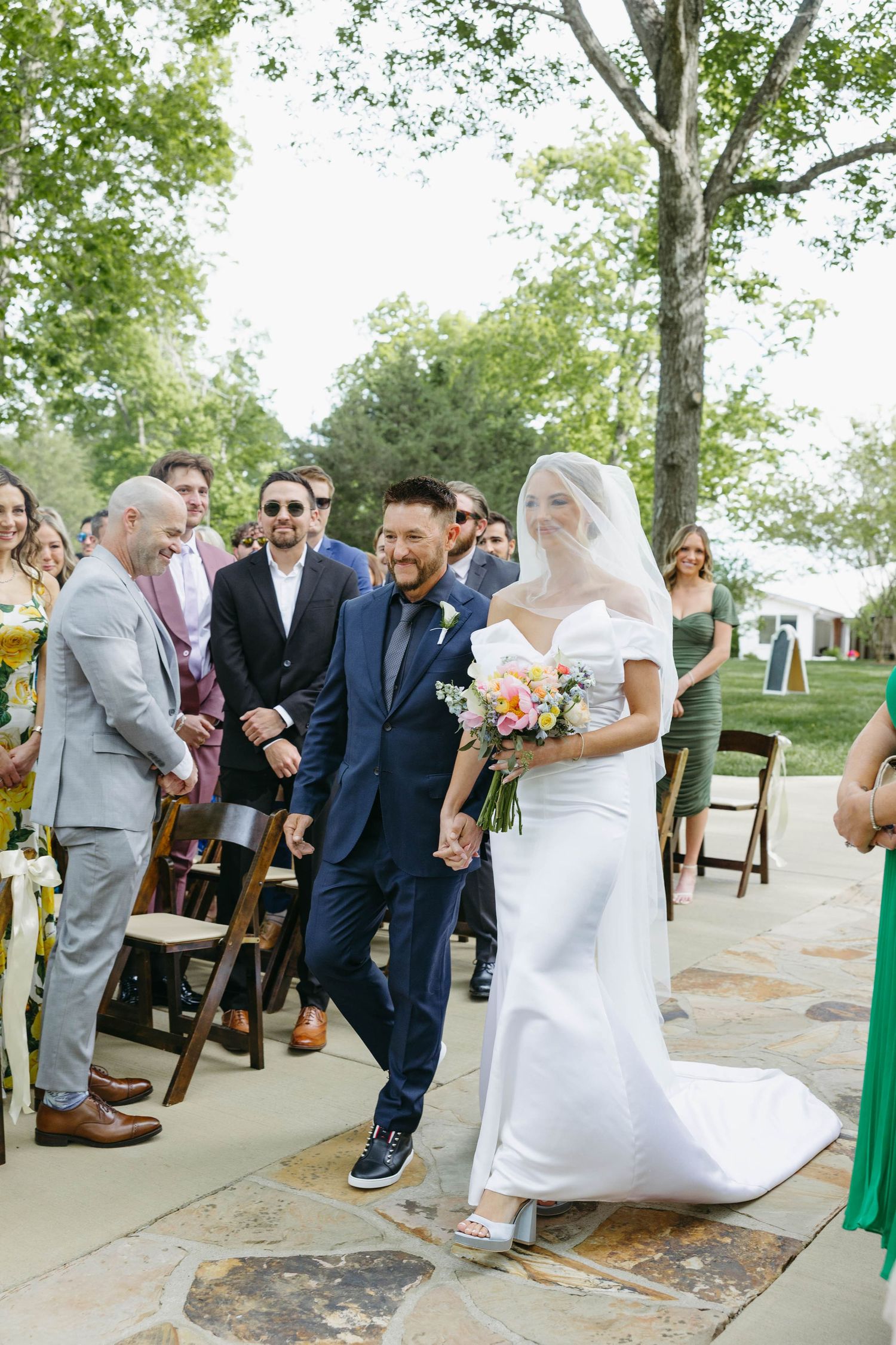Birmingham Alabama Photographer capturing bride walking down the isle at the ceremony space, at Iris Woods Venue in Nashville, Tennessee