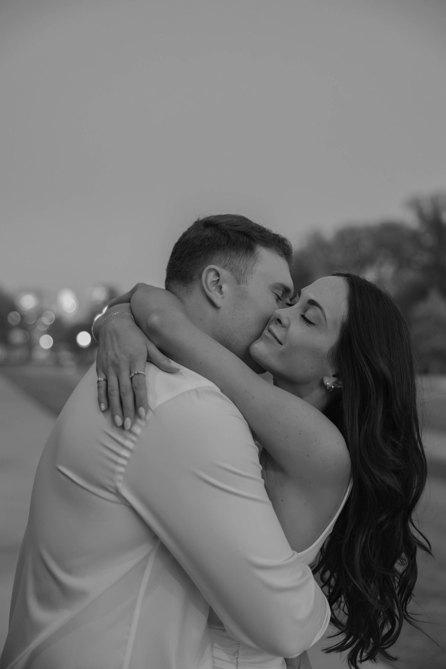 Birmingham Alabama Photographer capturing an engagement session of a couple hugging and smiling  in Nashville Tennessee at the Parthenon