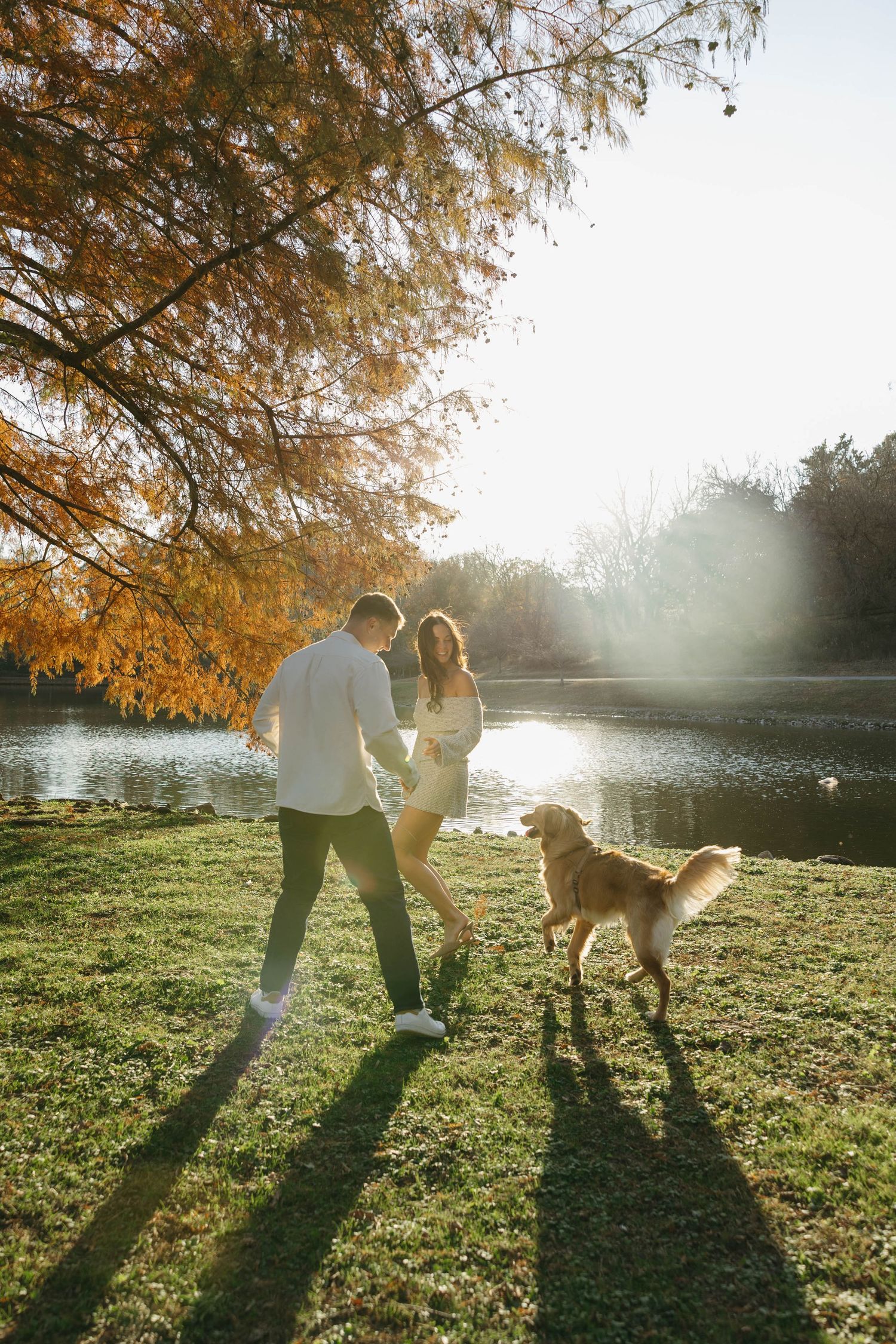 Birmingham Alabama Photographer capturing an engagement session of a couple running with golden retriever in a park in Nashville Tennessee